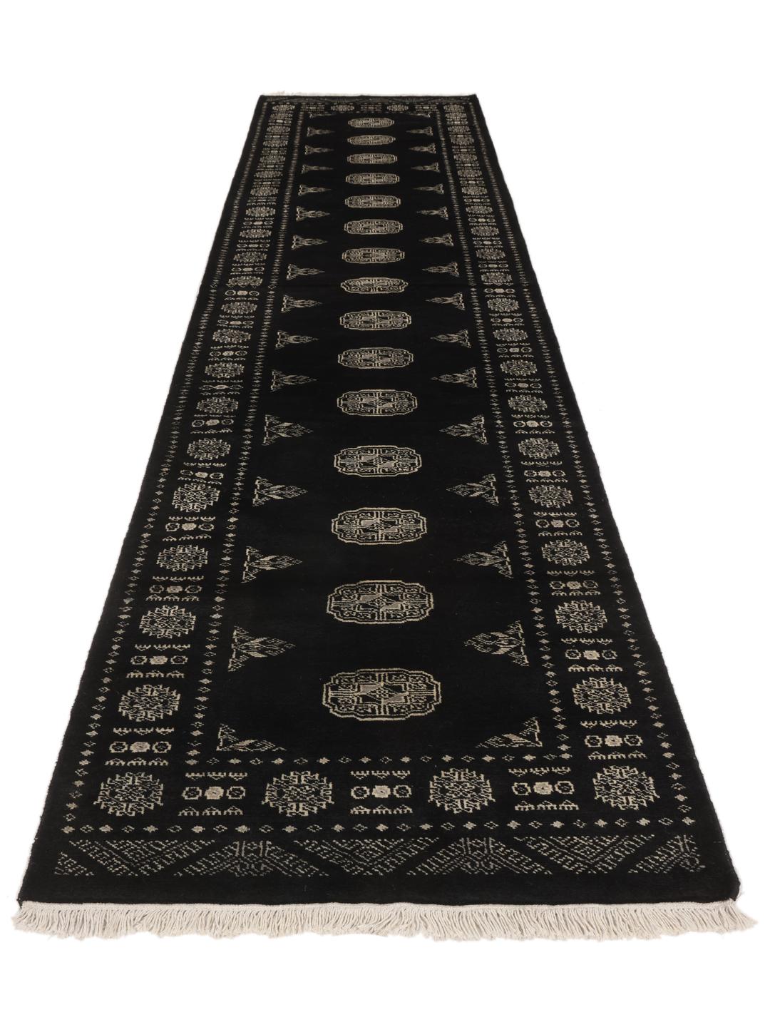 A hand-knotted Pakistan Bokhara runner featuring a black field with geometric motifs