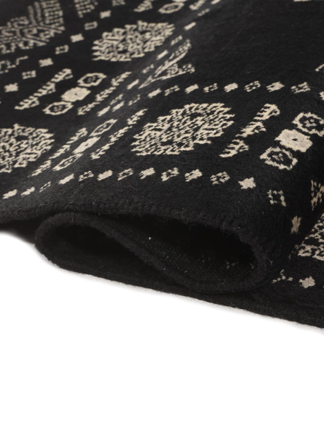 A hand-knotted Pakistan Bokhara runner featuring a black field with geometric motifs
