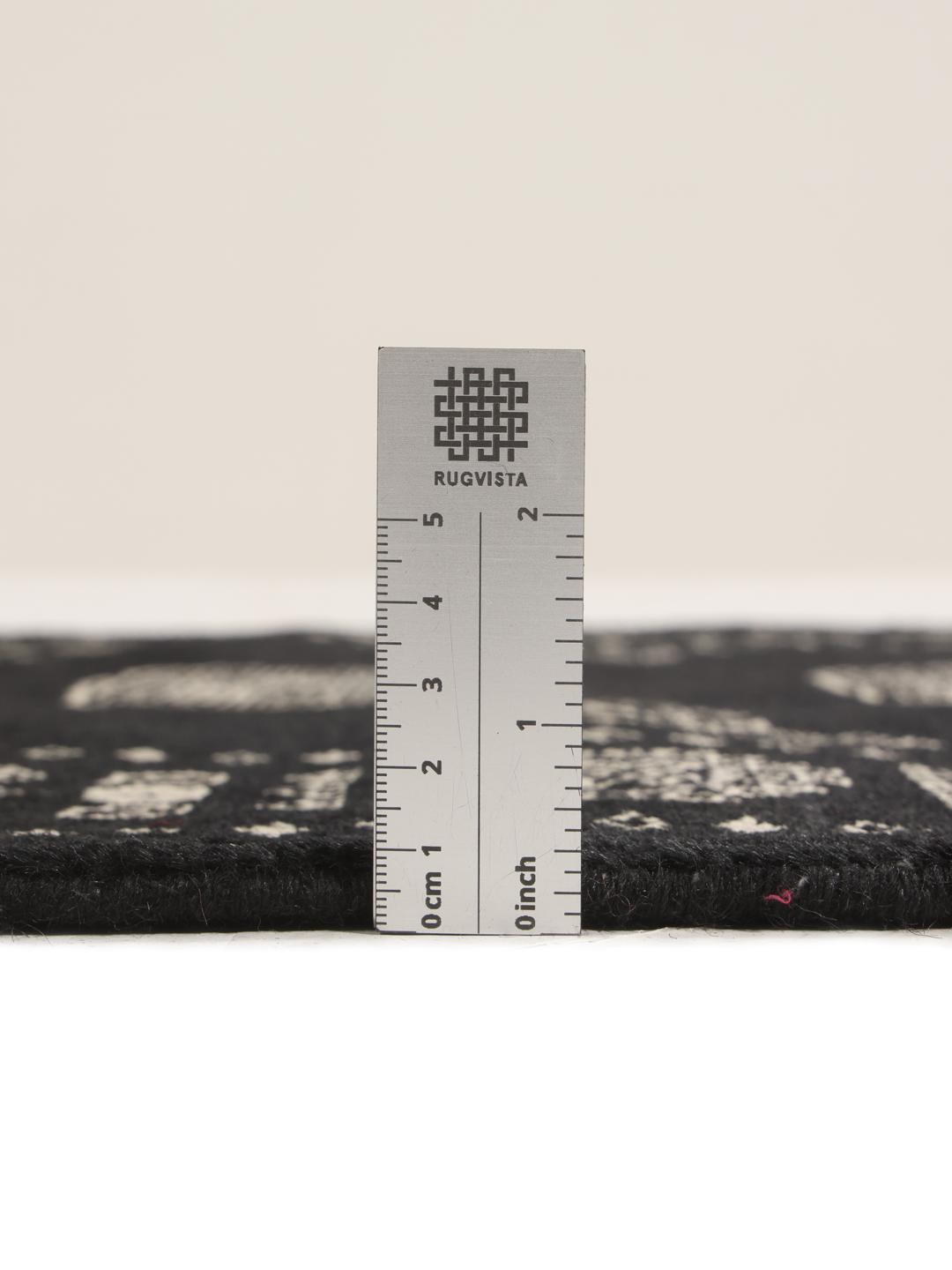 A hand-knotted Pakistan Bokhara runner featuring a black field with geometric motifs