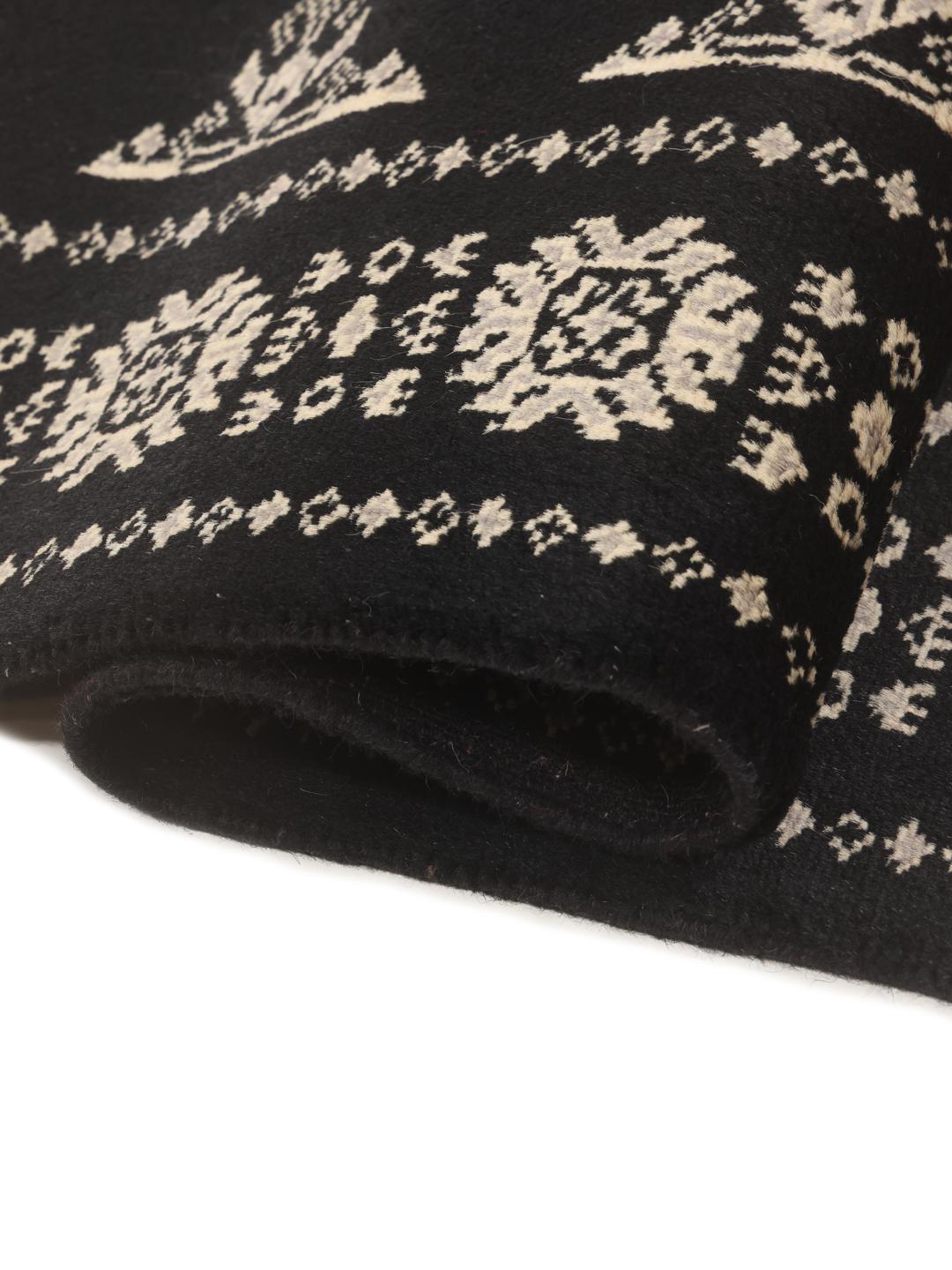 A long, black hand-knotted runner from Pakistan with traditional white motifs.