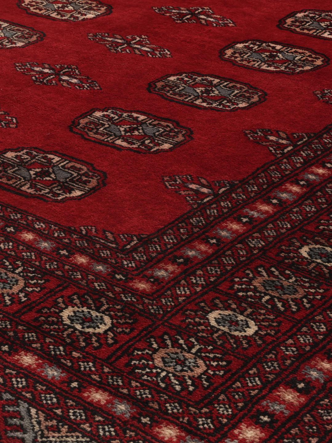 Hand-knotted Pakistan Bokhara 3ply rug with traditional red field and geometric motifs