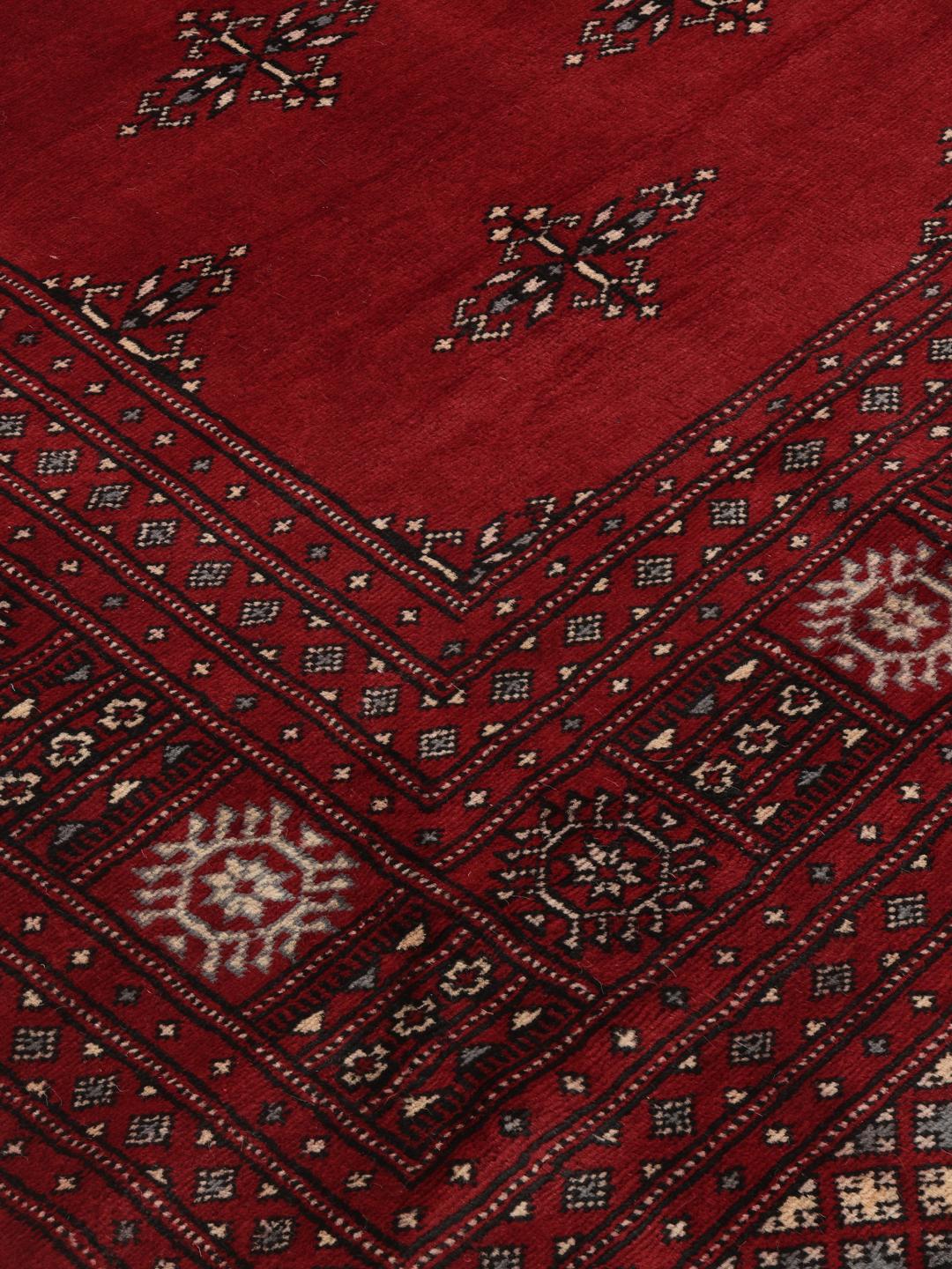 Een handgeknoopt Pakistan Bokhara-tapijt in dieprood met traditionele geometrische motieven.