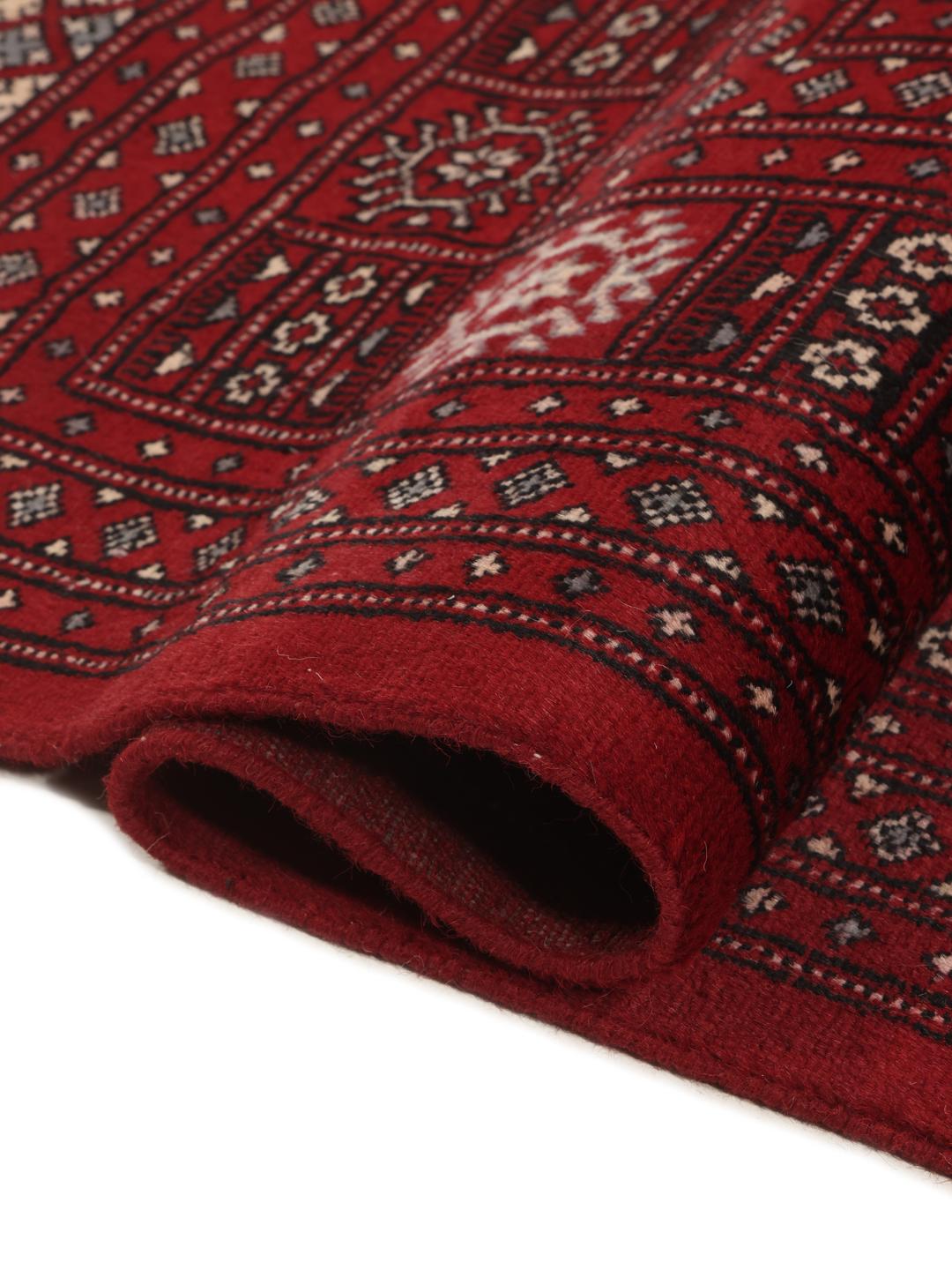 Een handgeknoopt Pakistan Bokhara-tapijt in dieprood met traditionele geometrische motieven.