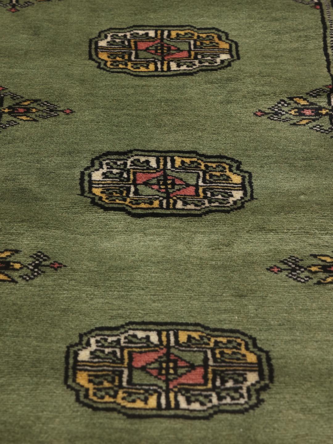 Hand-knotted Pakistan Bokhara rug in green with traditional motifs