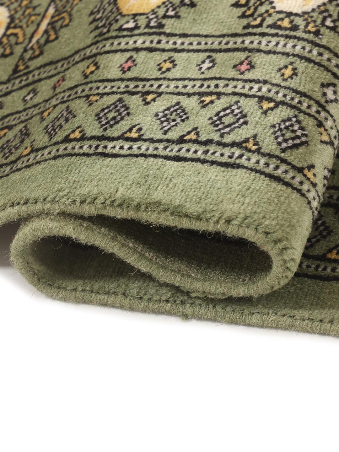 Hand-knotted Pakistan Bokhara rug in green with traditional motifs