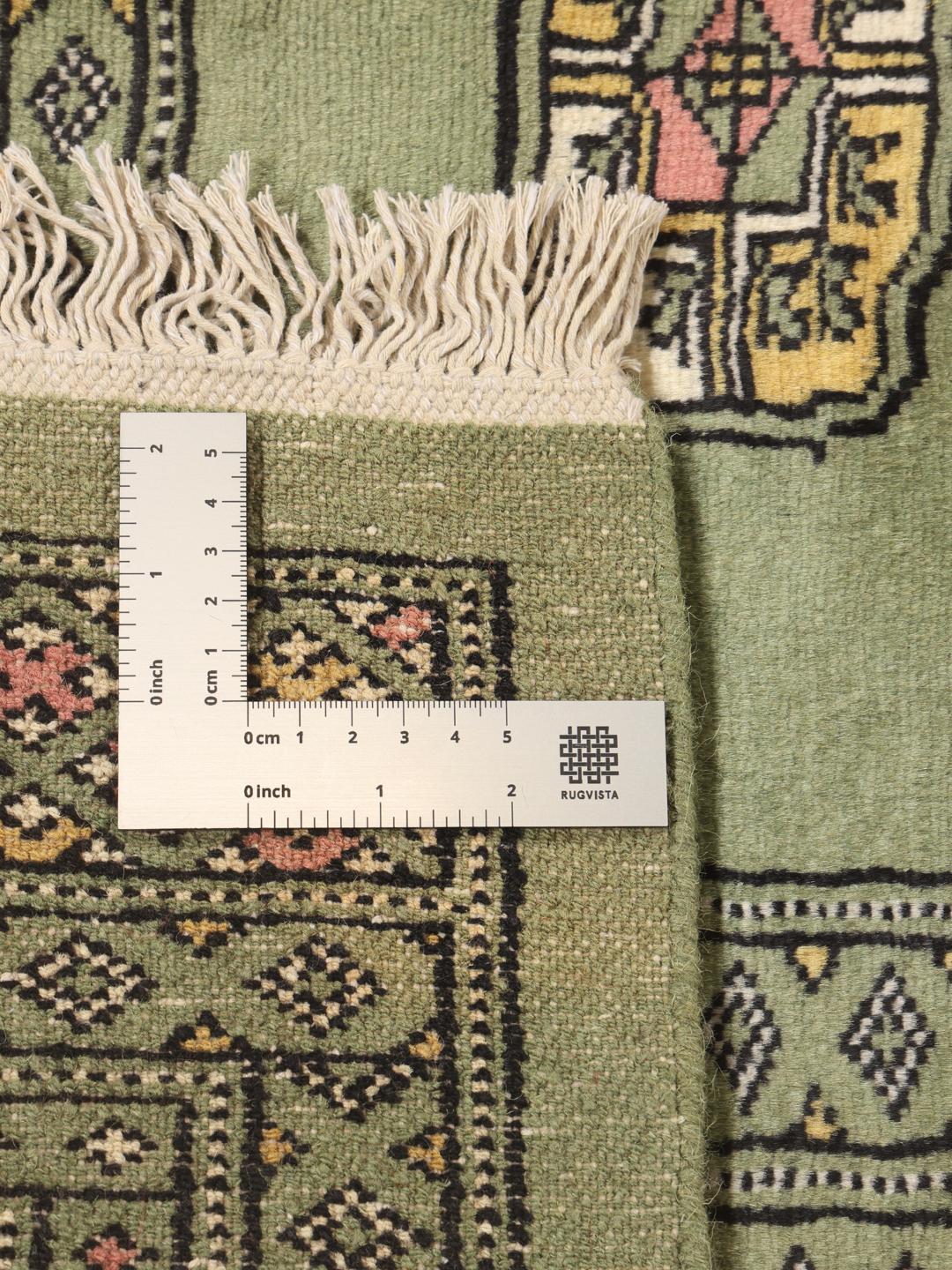 Hand-knotted Pakistan Bokhara rug in green with traditional motifs
