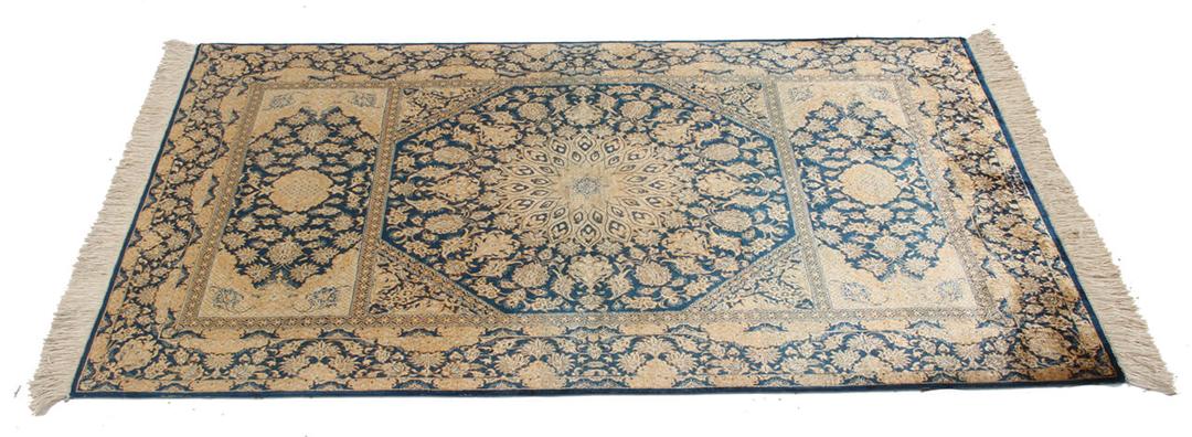 Een luxueus handgeknoopt Qum zijden tapijt uit het Midden-Oosten met blauwe en beige bloemmotieven.