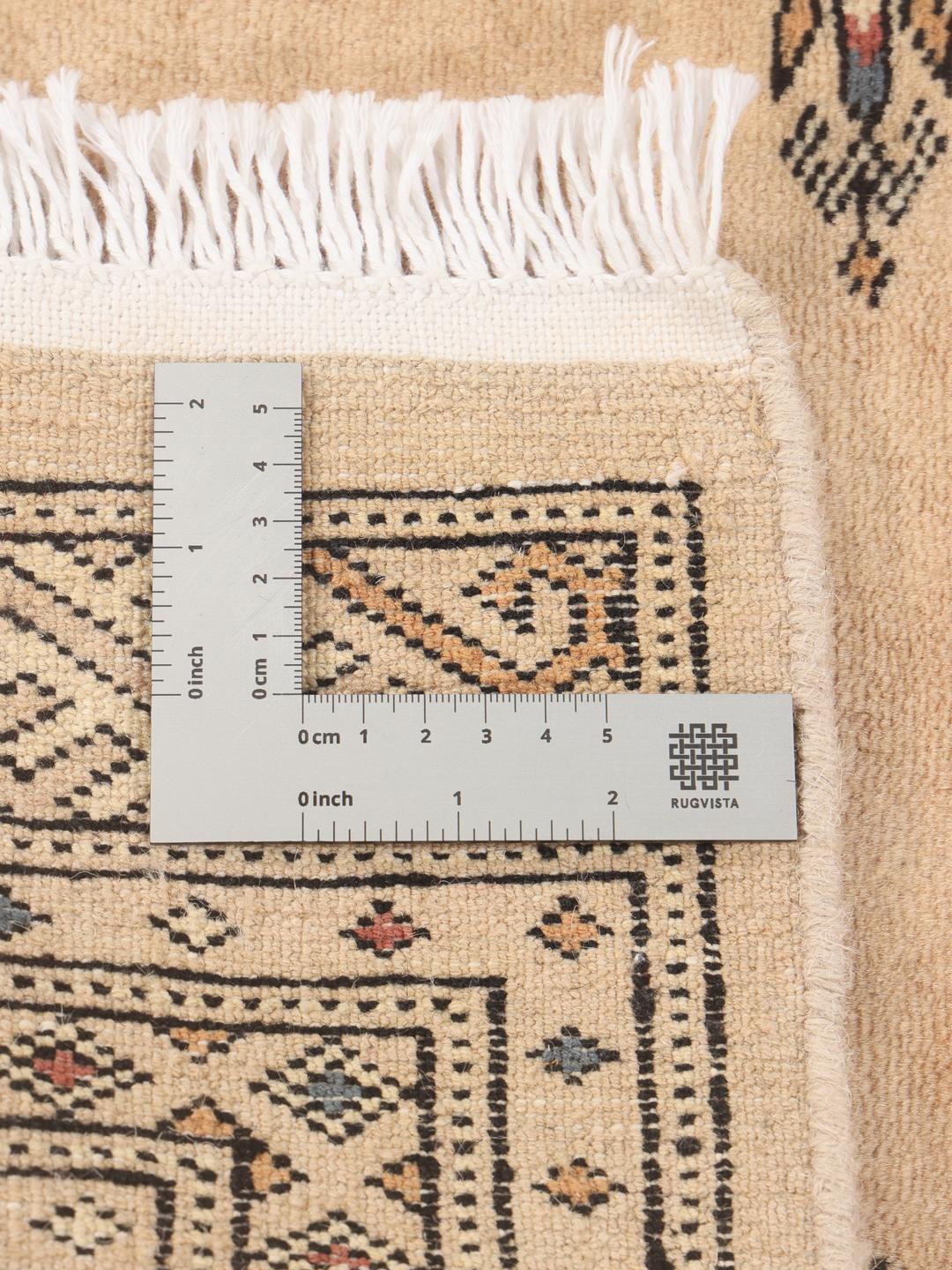 A hand-knotted Pakistani Bokhara rug in beige with traditional medallion motifs.