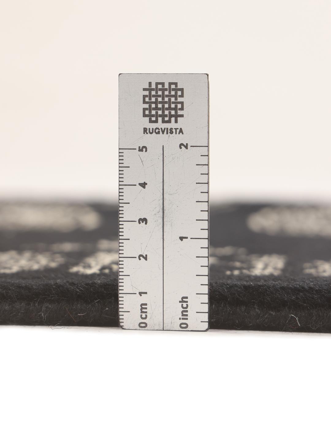 A long, hand-knotted runner from Pakistan with a black field and traditional patterns.