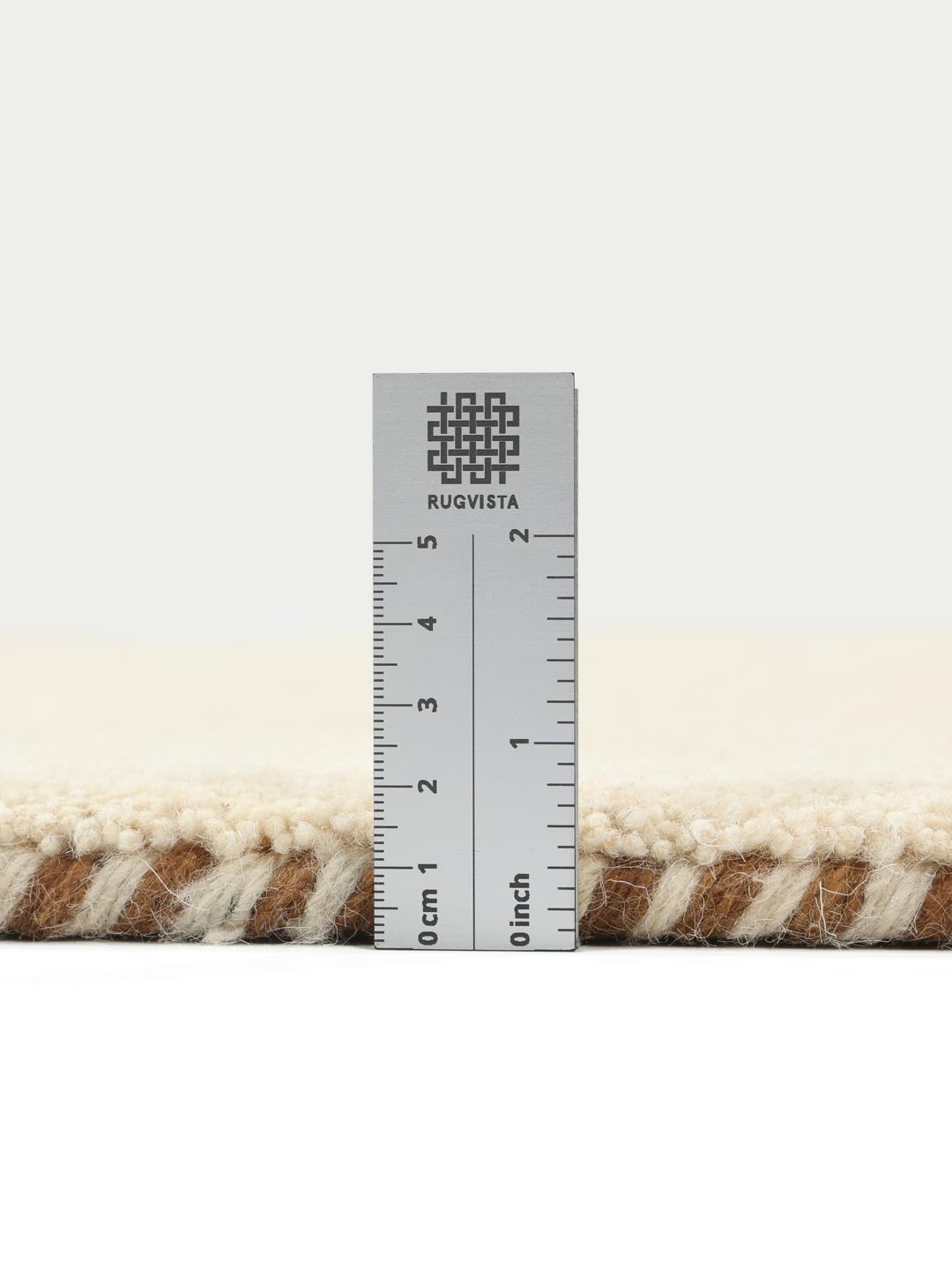 Et beige tæppe med små, spredte dekorative motiver.