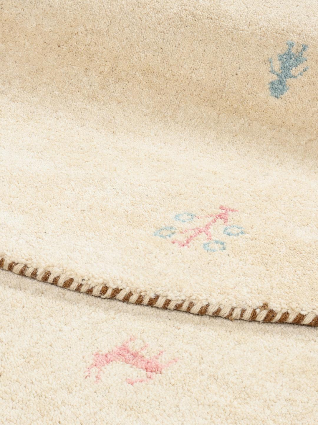 Rundt beige tæppe med billedmotiver