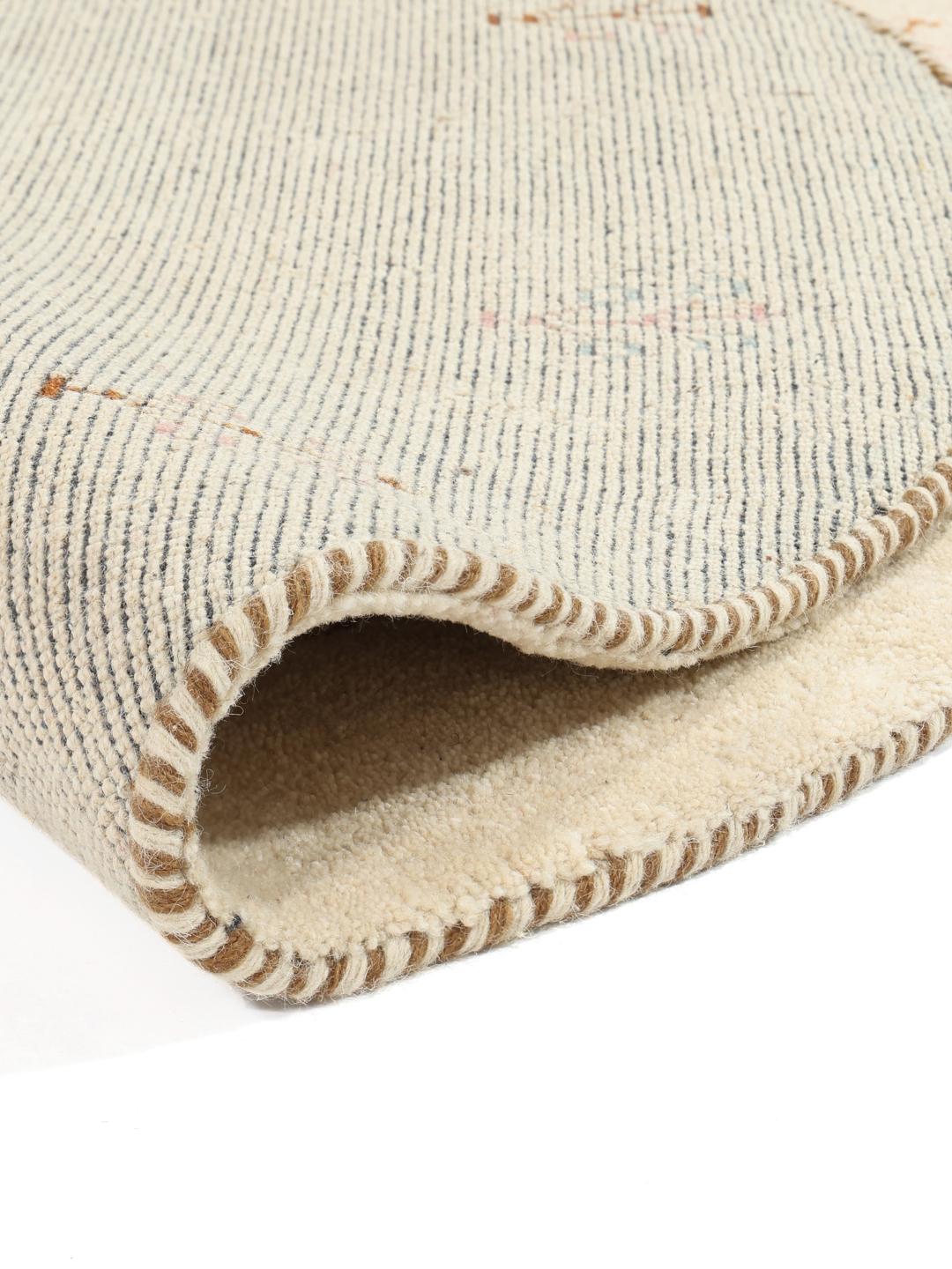 Rundt beige tæppe med billedmotiver