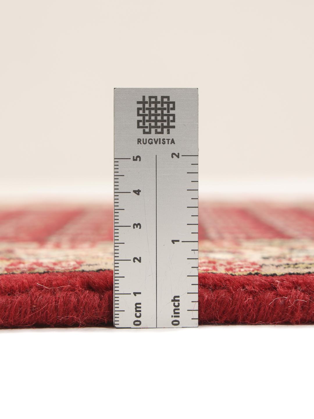 Un long tapis de couloir Mir Indo noué à la main, originaire d'Inde, avec un champ rouge profond et un motif floral complexe.