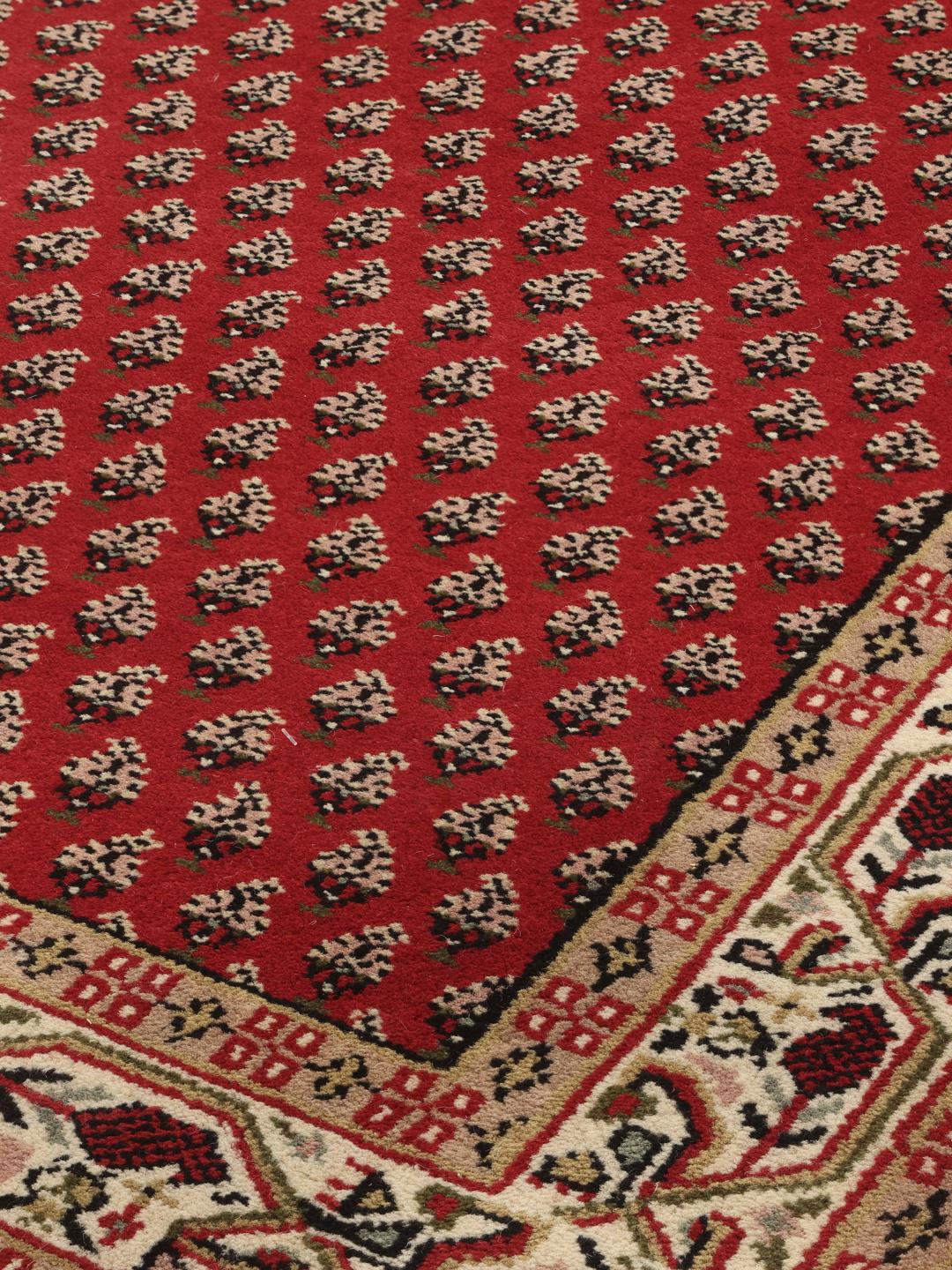 Un long tapis de couloir Mir Indo noué à la main, originaire d'Inde, avec un champ rouge profond et un motif floral complexe.