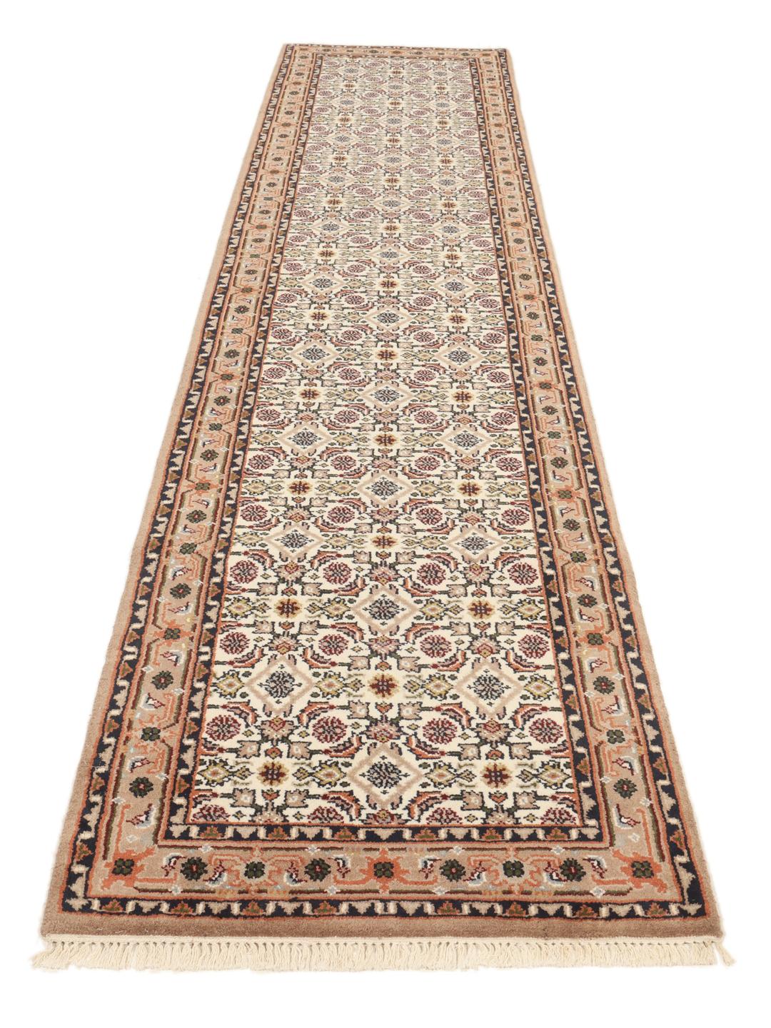 Un tapis de couloir beige noué à la main en provenance d'Inde avec un motif traditionnel.