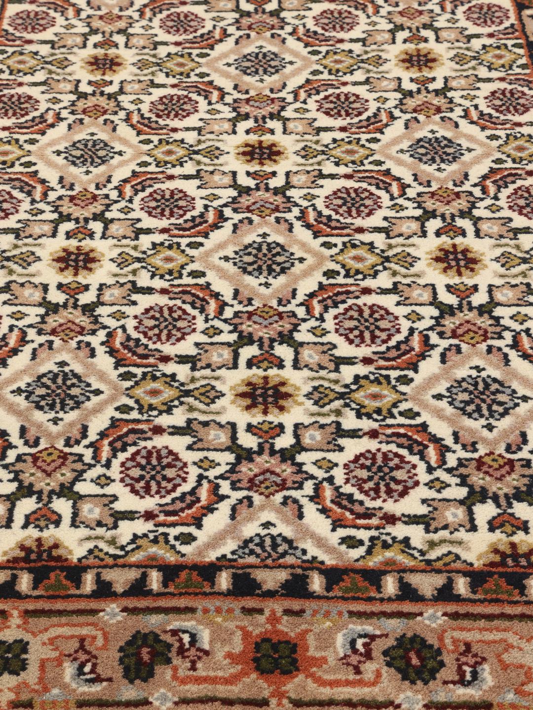 Un tapis de couloir beige noué à la main en provenance d'Inde avec un motif traditionnel.