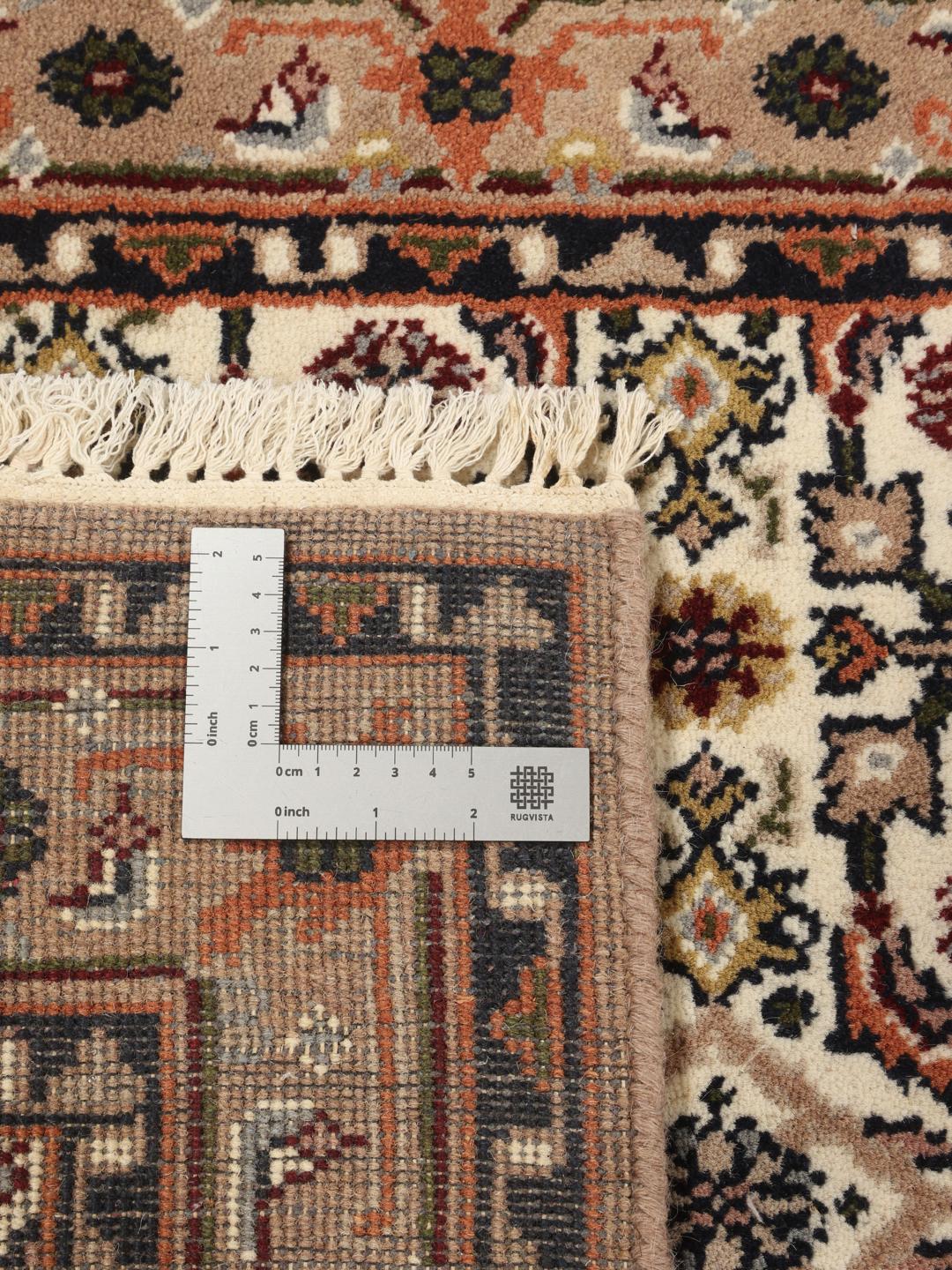 Un tapis de couloir beige noué à la main en provenance d'Inde avec un motif traditionnel.