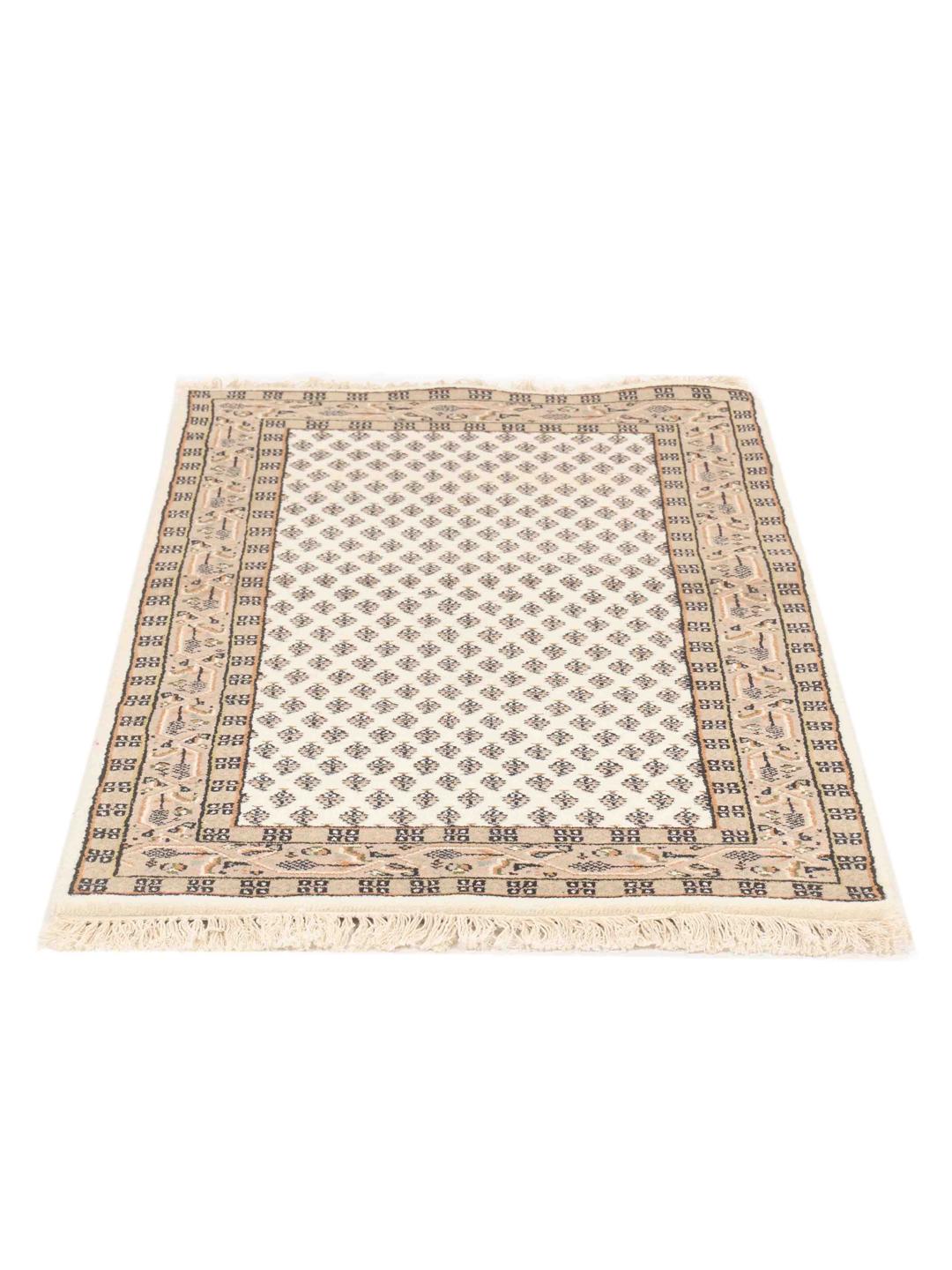 Un tapis Mir Indo beige noué à la main avec d'élégants motifs répétitifs.