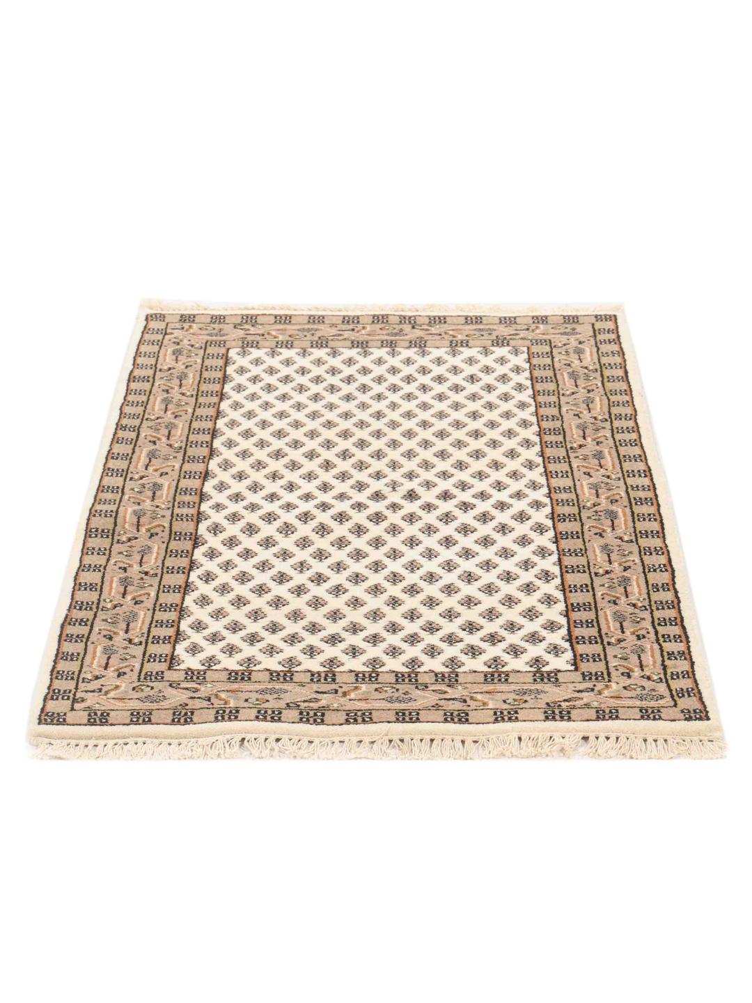 Un tapis Mir Indo beige noué à la main avec d'élégants motifs répétitifs.