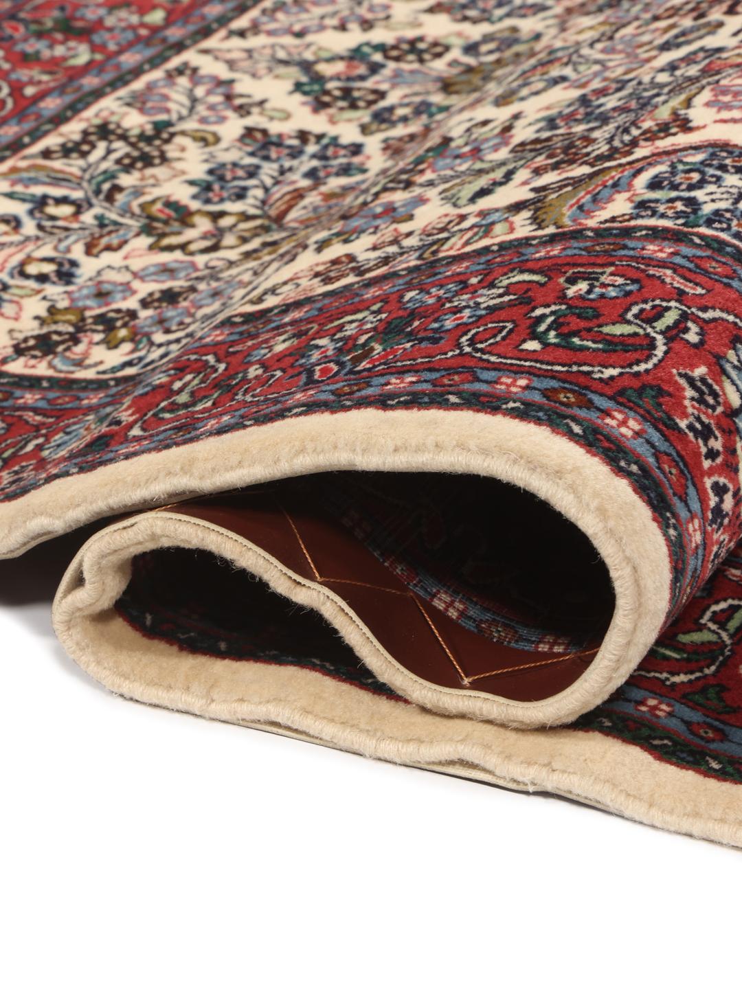 Hand-knotted Sarough rug with a floral vase pattern in red and beige tones.