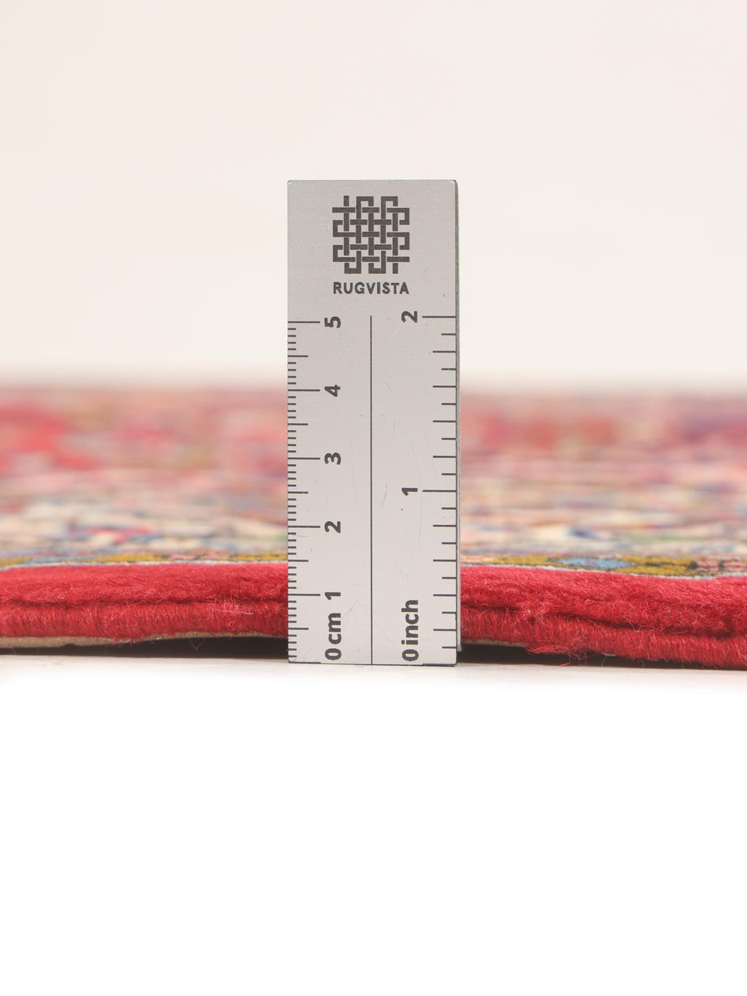 A hand-knotted Sarough rug from the Middle East featuring a vibrant red field with intricate floral patterns.
