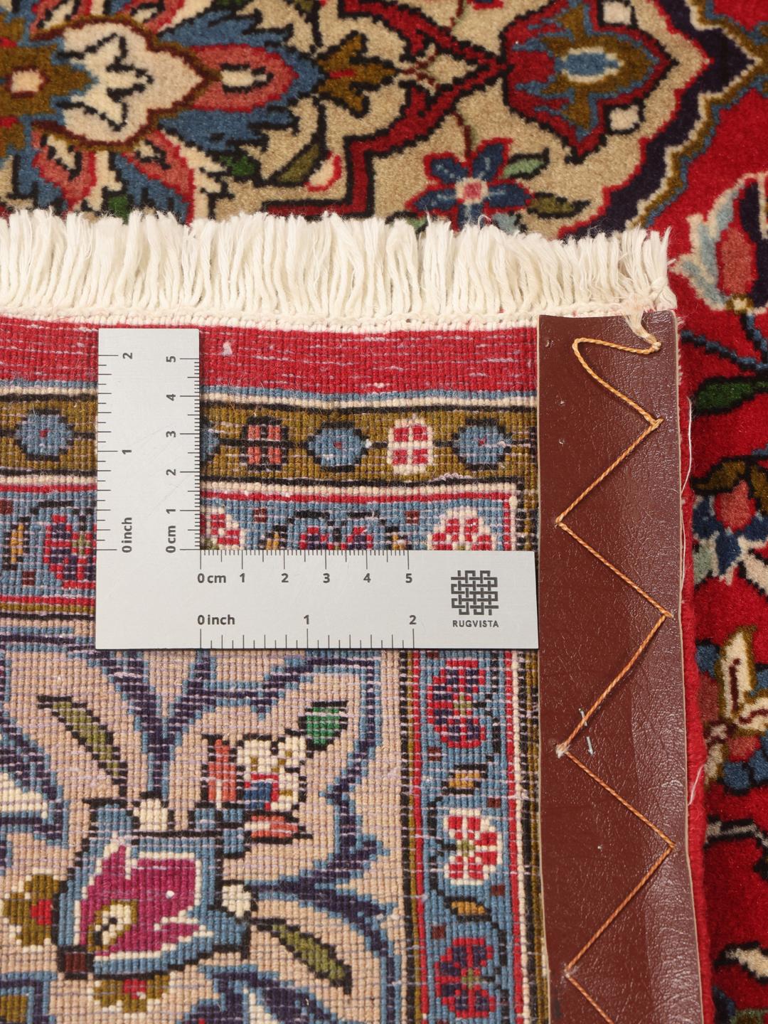 A hand-knotted Sarough rug from the Middle East featuring a vibrant red field with intricate floral patterns.
