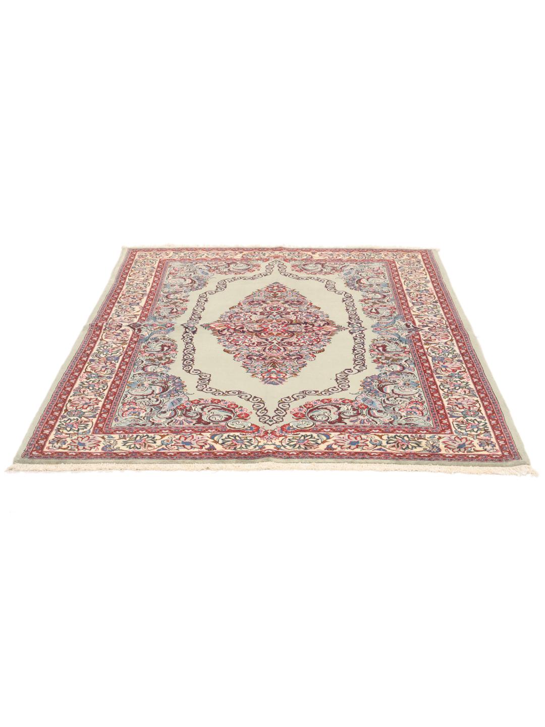 A hand-knotted Sarough rug from the Middle East with a light-green field and intricate floral medallion.