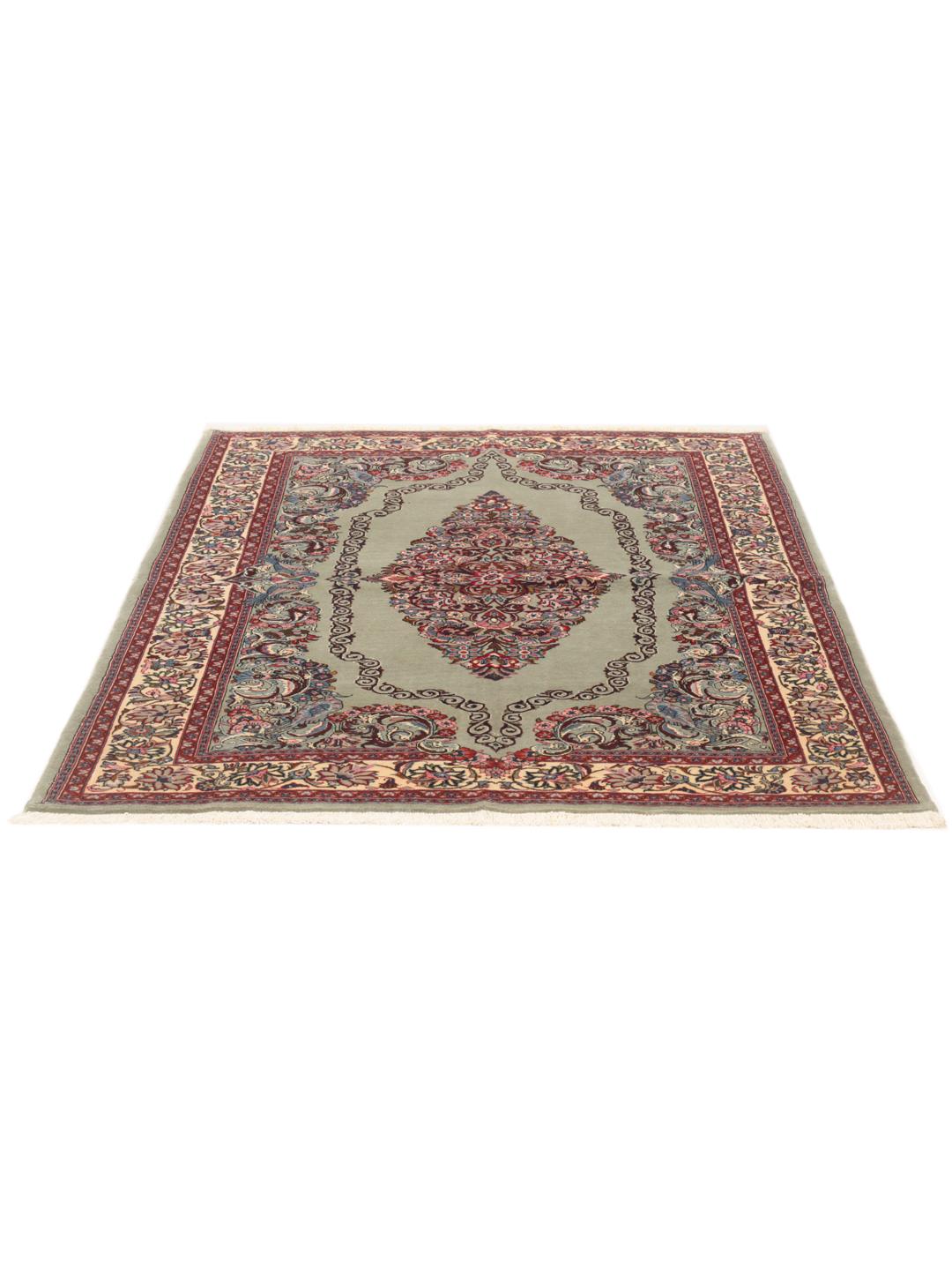 A hand-knotted Sarough rug from the Middle East with a light-green field and intricate floral medallion.