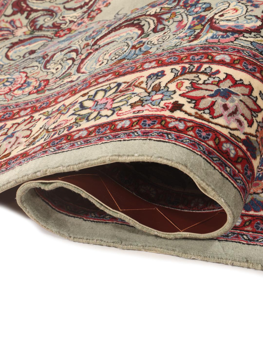 A hand-knotted Sarough rug from the Middle East with a light-green field and intricate floral medallion.