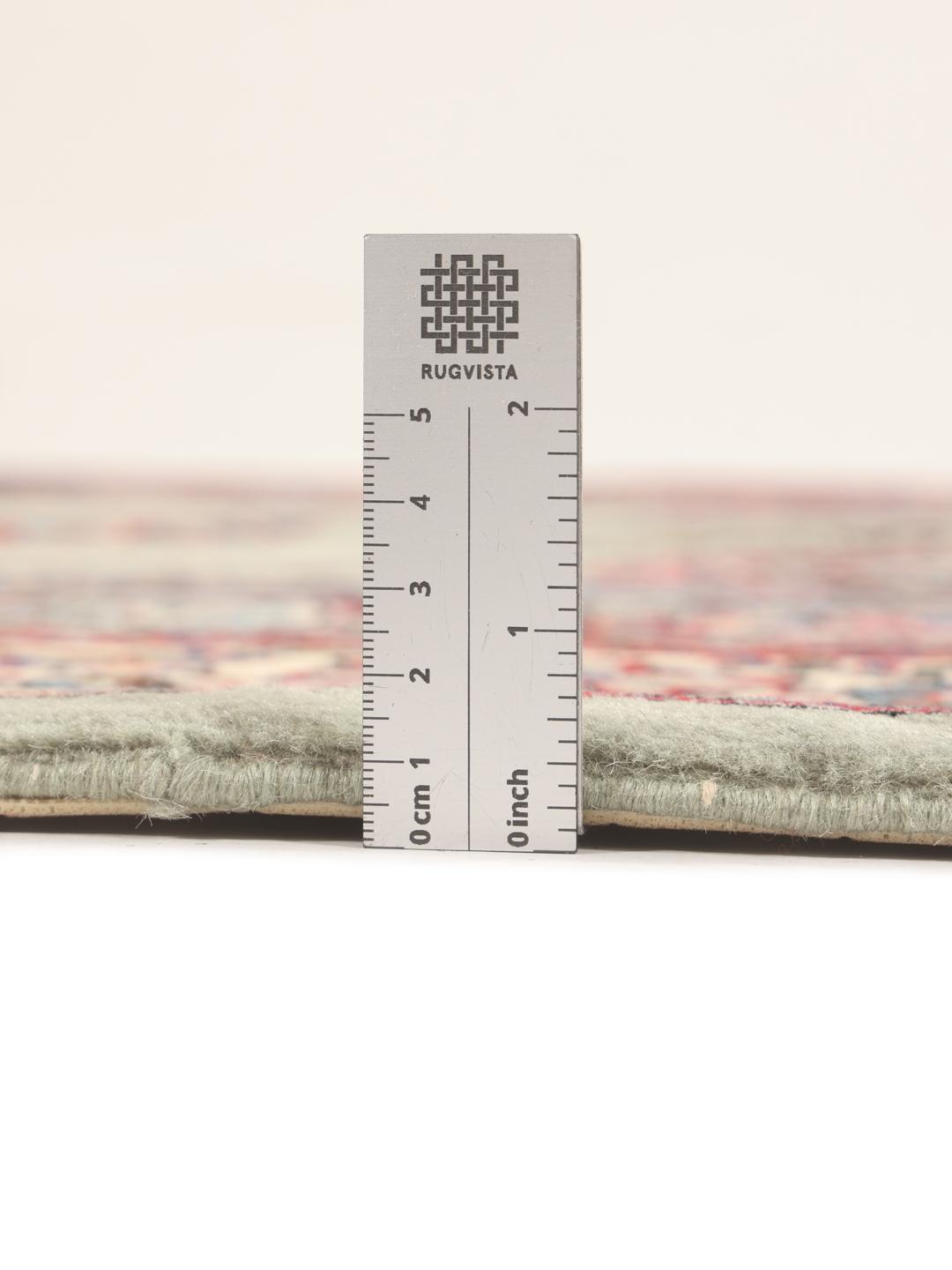 A hand-knotted Sarough rug from the Middle East with a light-green field and intricate floral medallion.