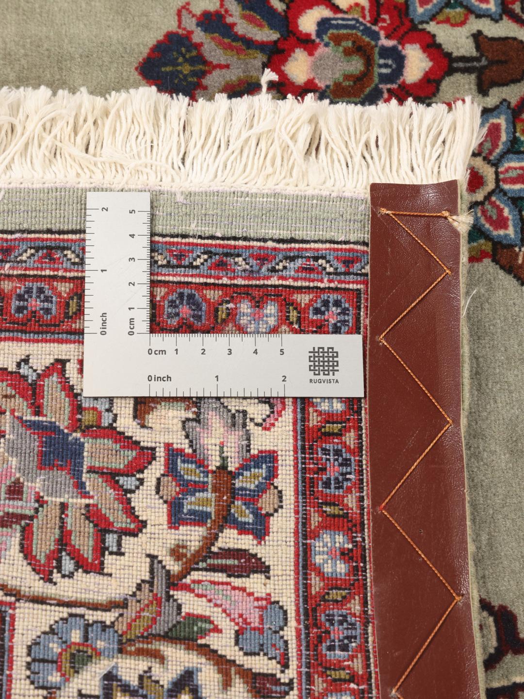 A hand-knotted Sarough rug from the Middle East with a light-green field and intricate floral medallion.