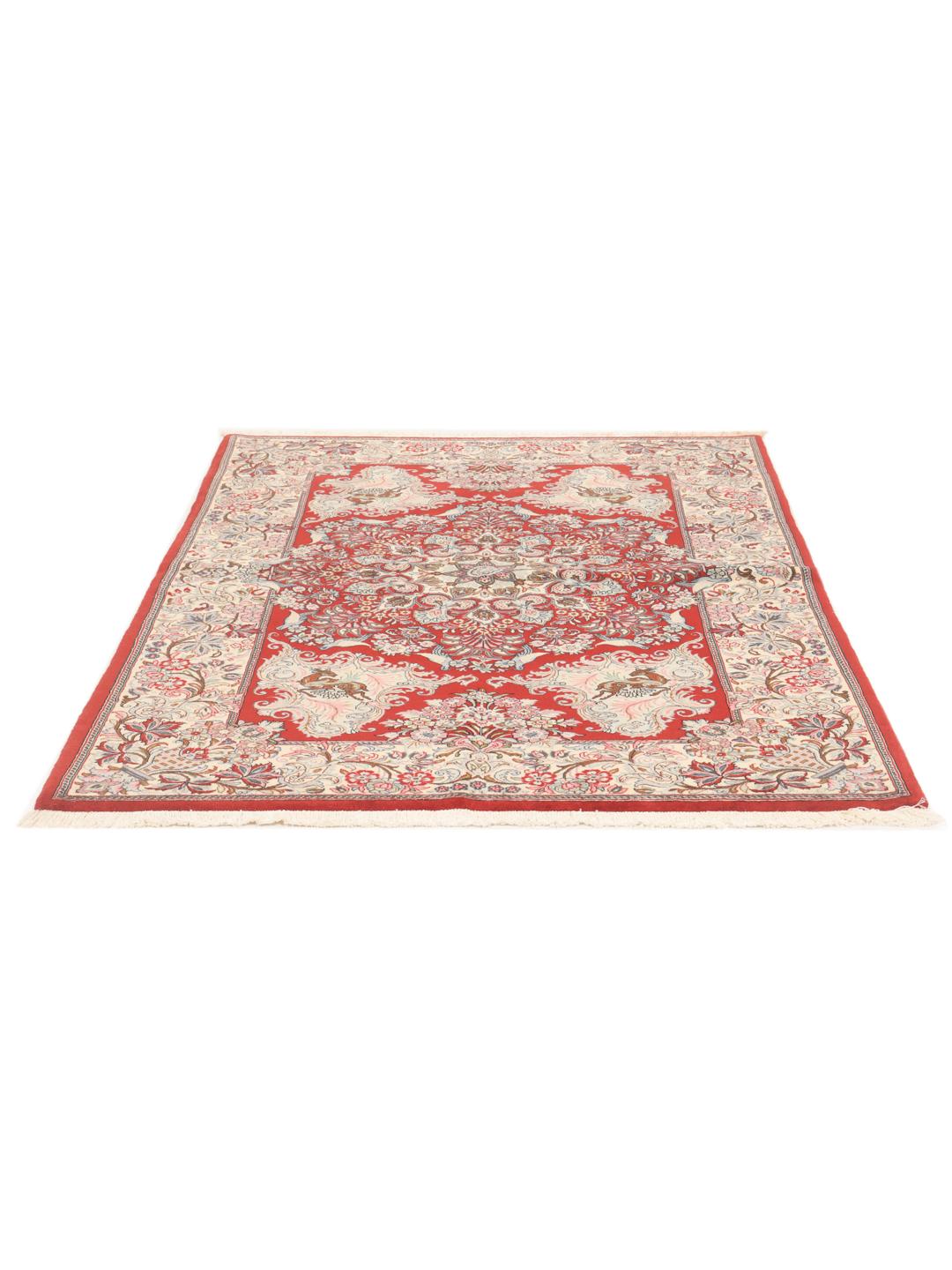 A hand-knotted Sarough rug from the Middle East featuring a red field with floral patterns.