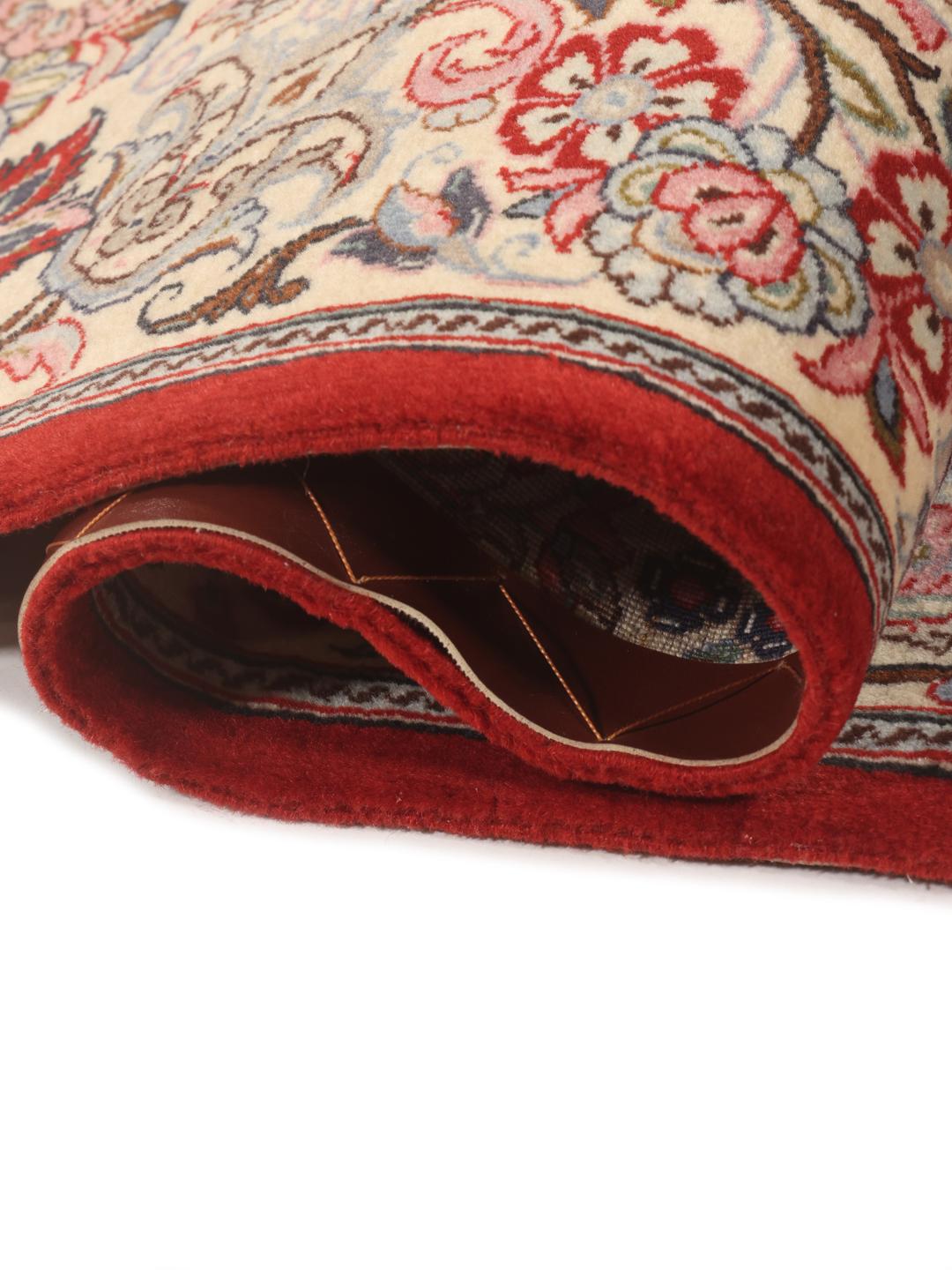 A hand-knotted Sarough rug from the Middle East featuring a red field with floral patterns.