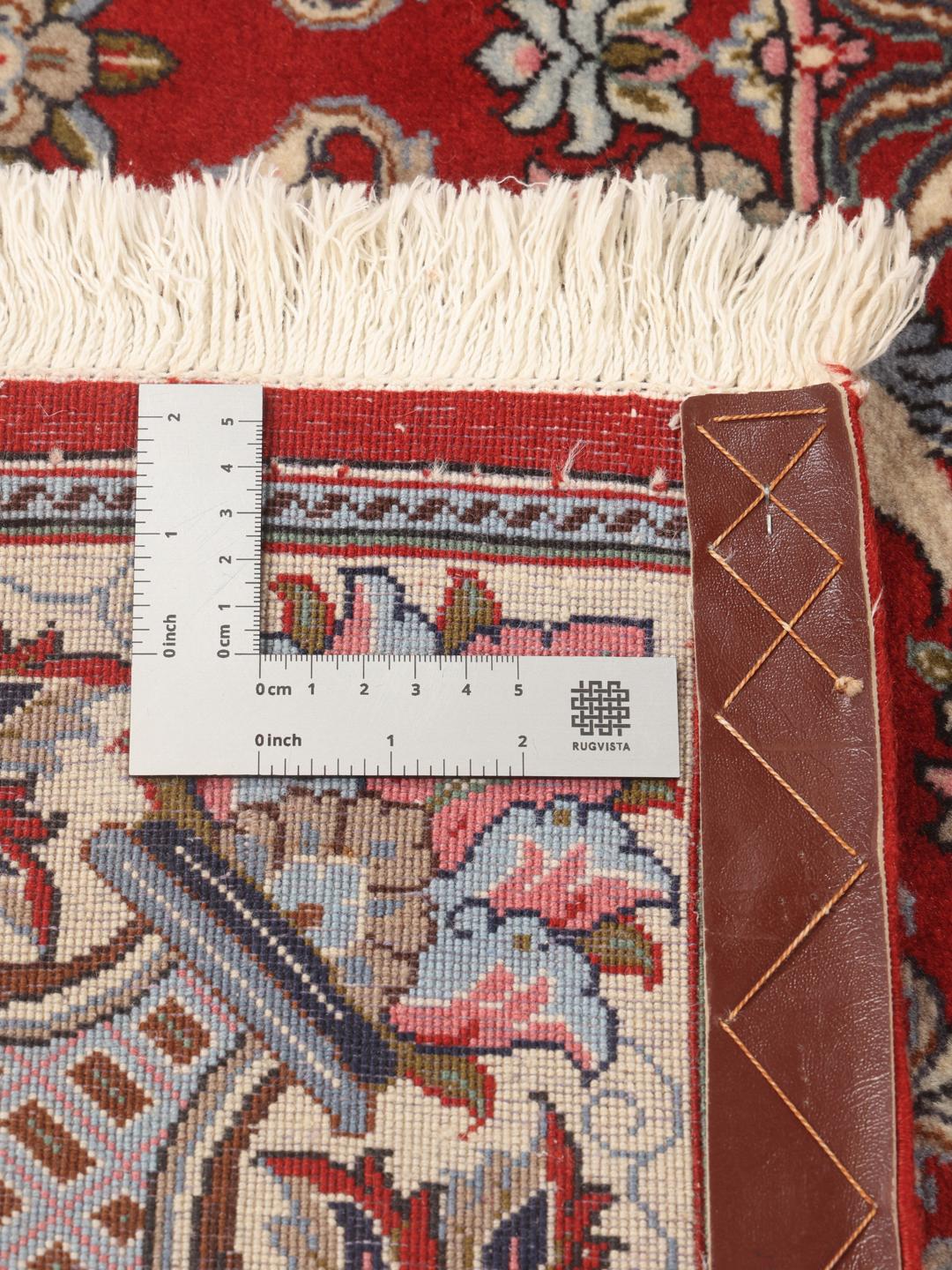A hand-knotted Sarough rug from the Middle East featuring a red field with floral patterns.