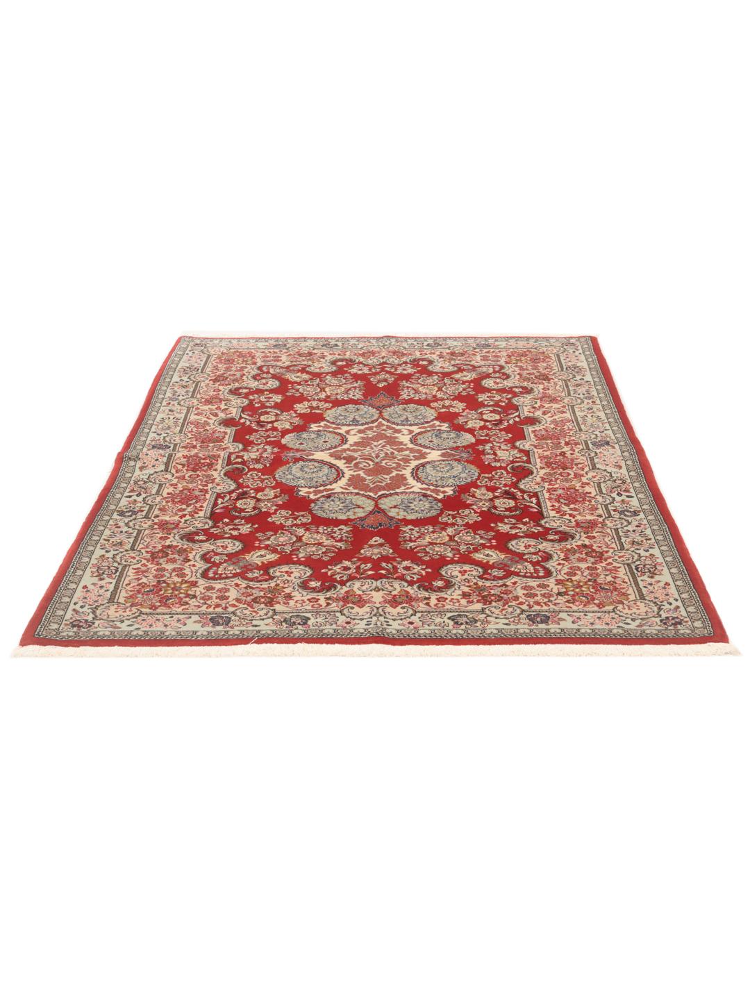 A hand-knotted red Sarough rug with intricate floral patterns.