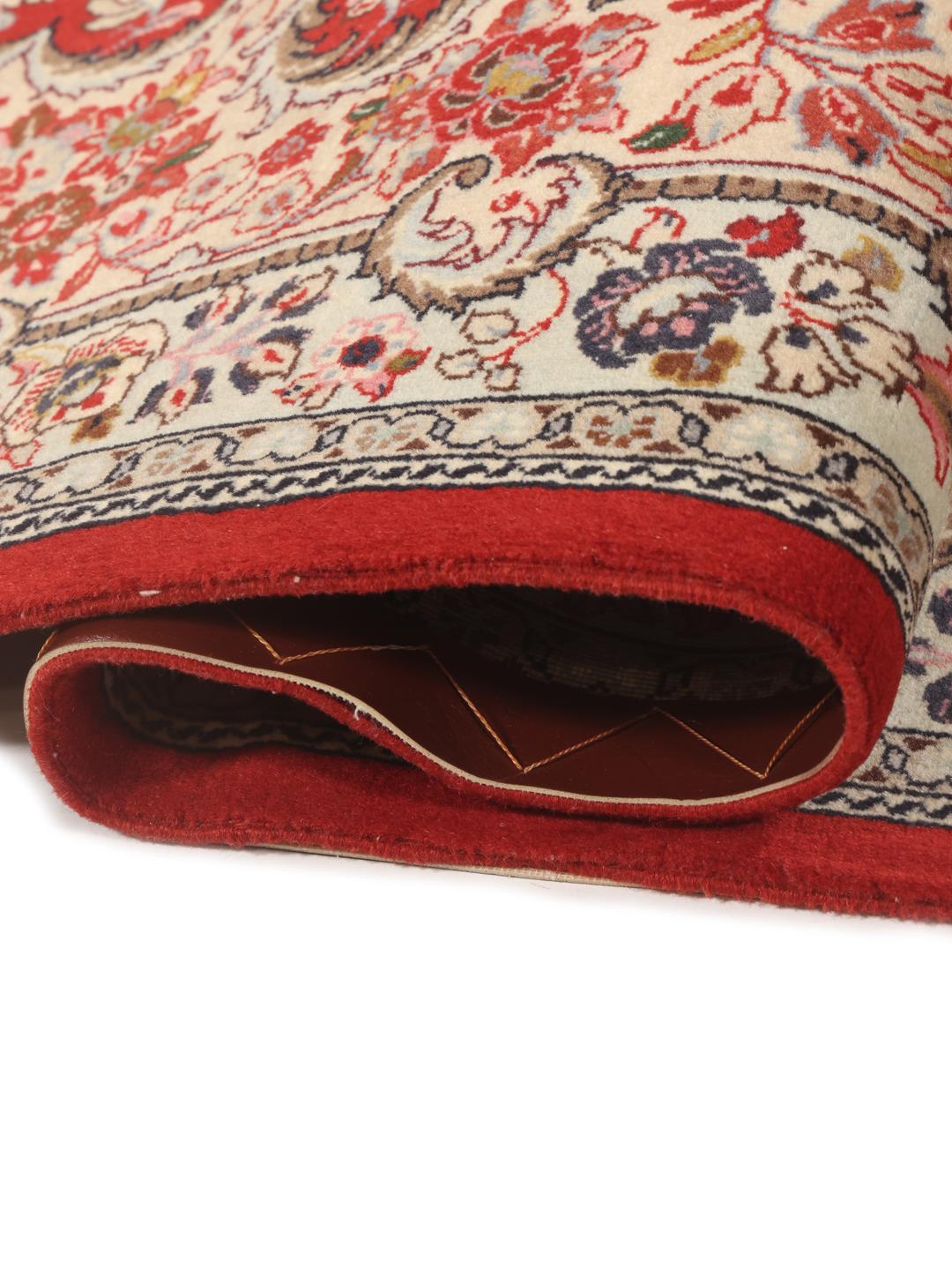 A hand-knotted red Sarough rug with intricate floral patterns.