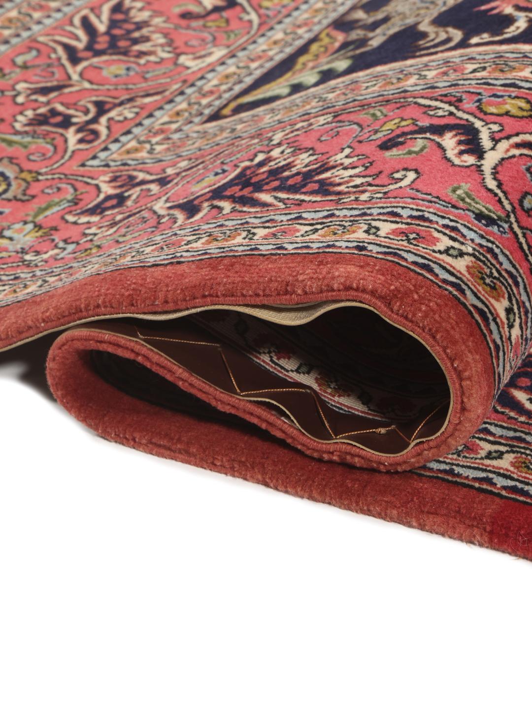 A hand-knotted Sarouk rug from the Middle East featuring a dark-blue field with colourful floral motifs