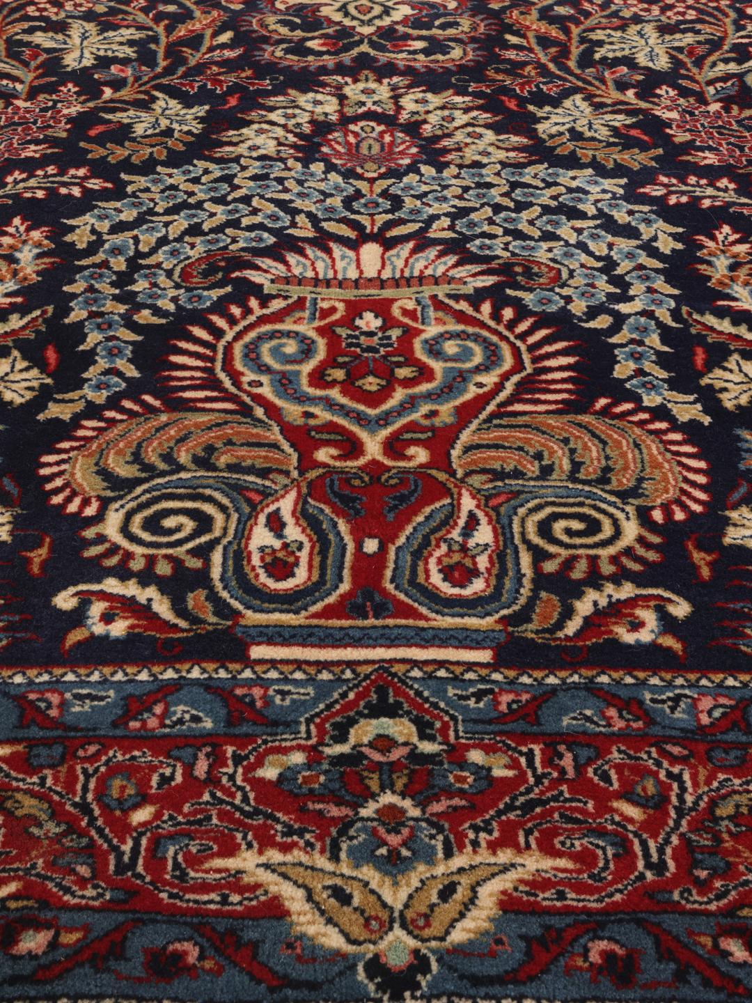 Hand-knotted Sarough rug featuring a traditional floral mihrab design in deep blue and red tones.