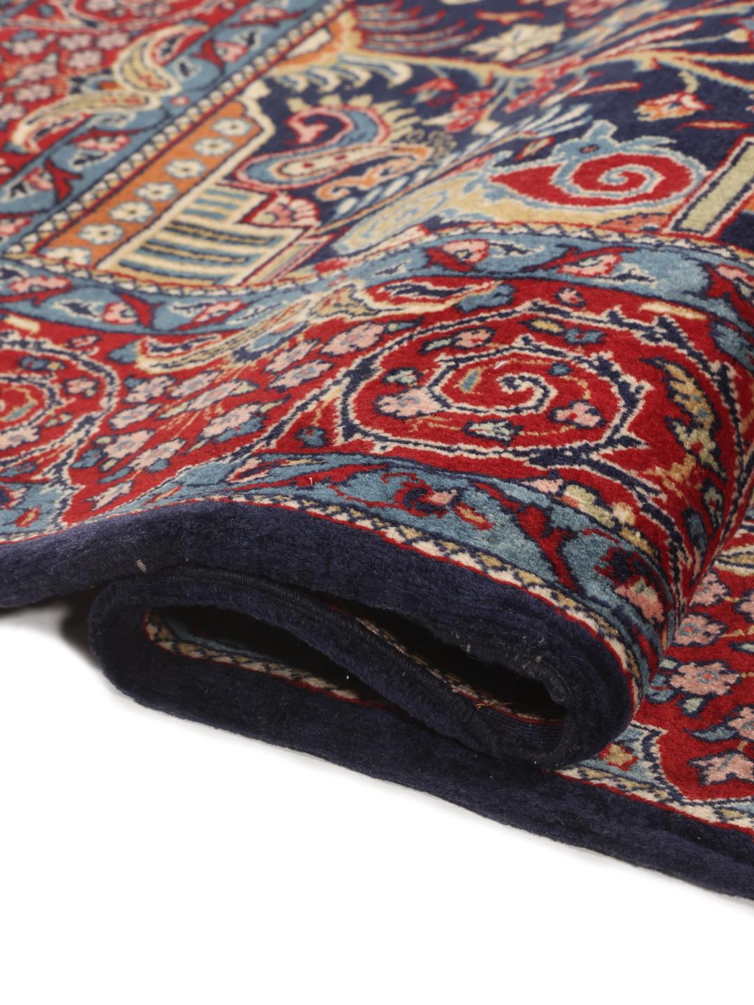 Hand-knotted Sarough rug featuring a traditional floral mihrab design in deep blue and red tones.