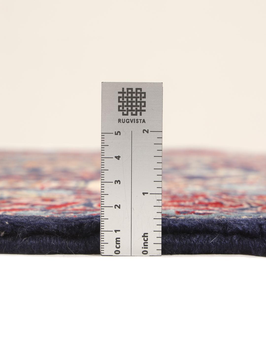 Hand-knotted Sarough rug featuring a traditional floral mihrab design in deep blue and red tones.