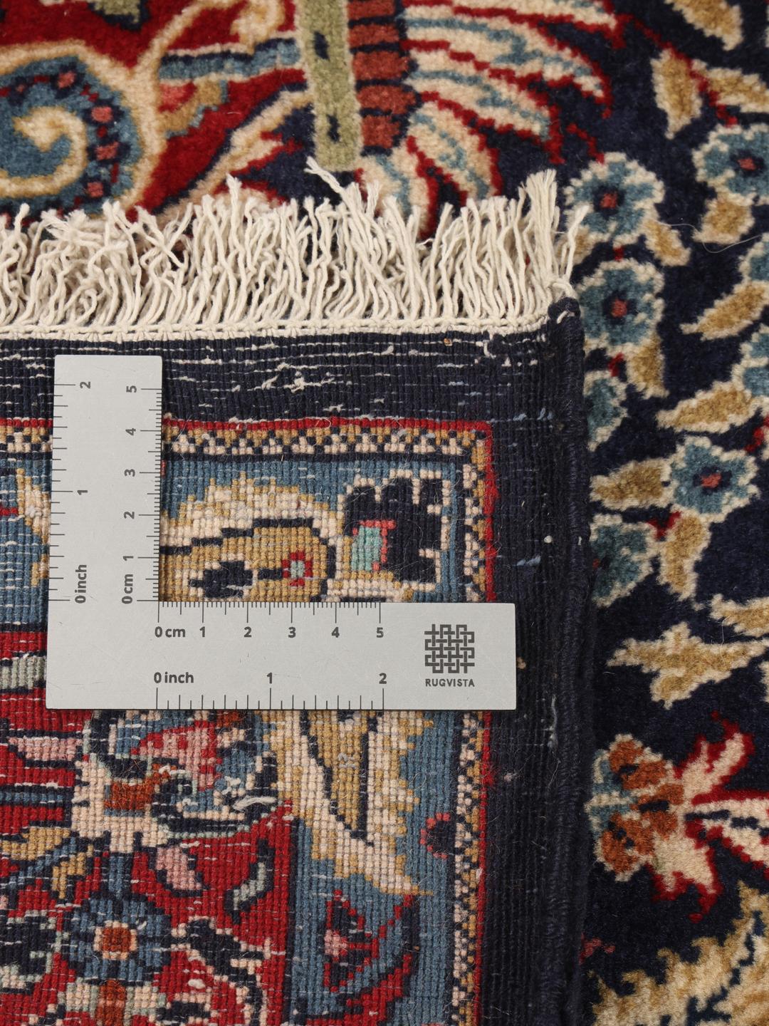 Hand-knotted Sarough rug featuring a traditional floral mihrab design in deep blue and red tones.