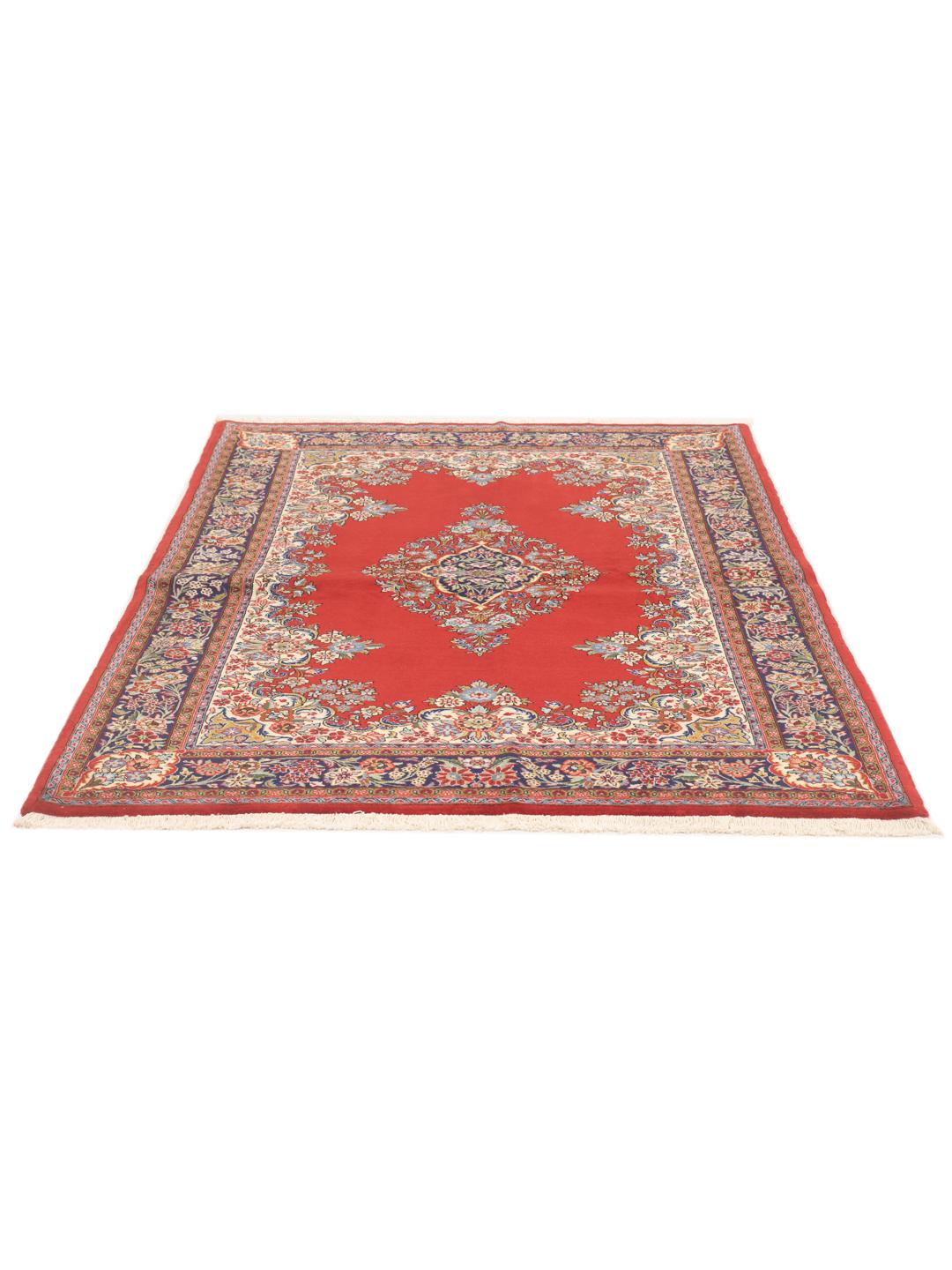 A hand-knotted Sarough rug from the Middle East with a red field and floral motifs.