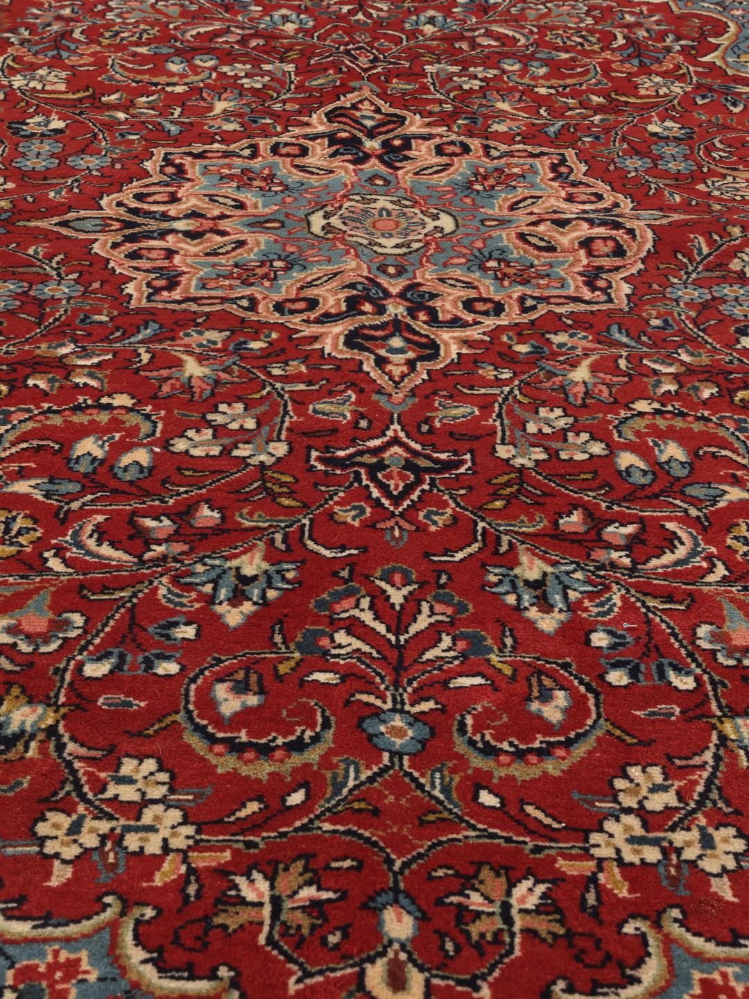 Hand-knotted Sarough rug from the Middle East with a red and blue floral pattern.