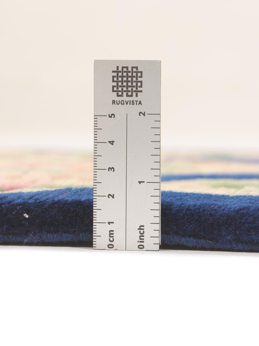 A rectangular hand-knotted rug from China featuring a deep blue field with floral motifs.