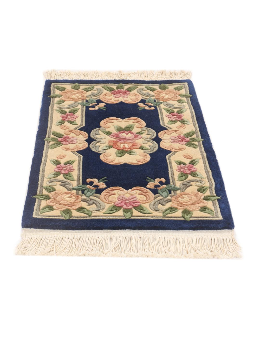 A rectangular hand-knotted rug from China featuring a deep blue field with floral motifs.