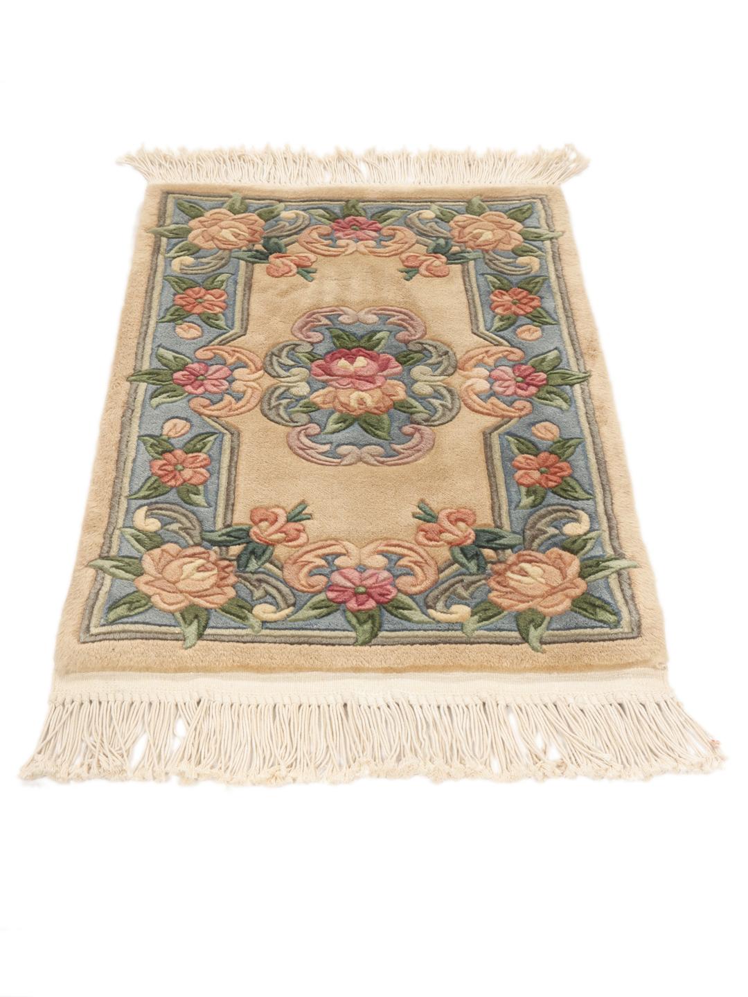 Et rektangulært tæppe fra Kina med blomstermønstre i beige, blå og lyserød.