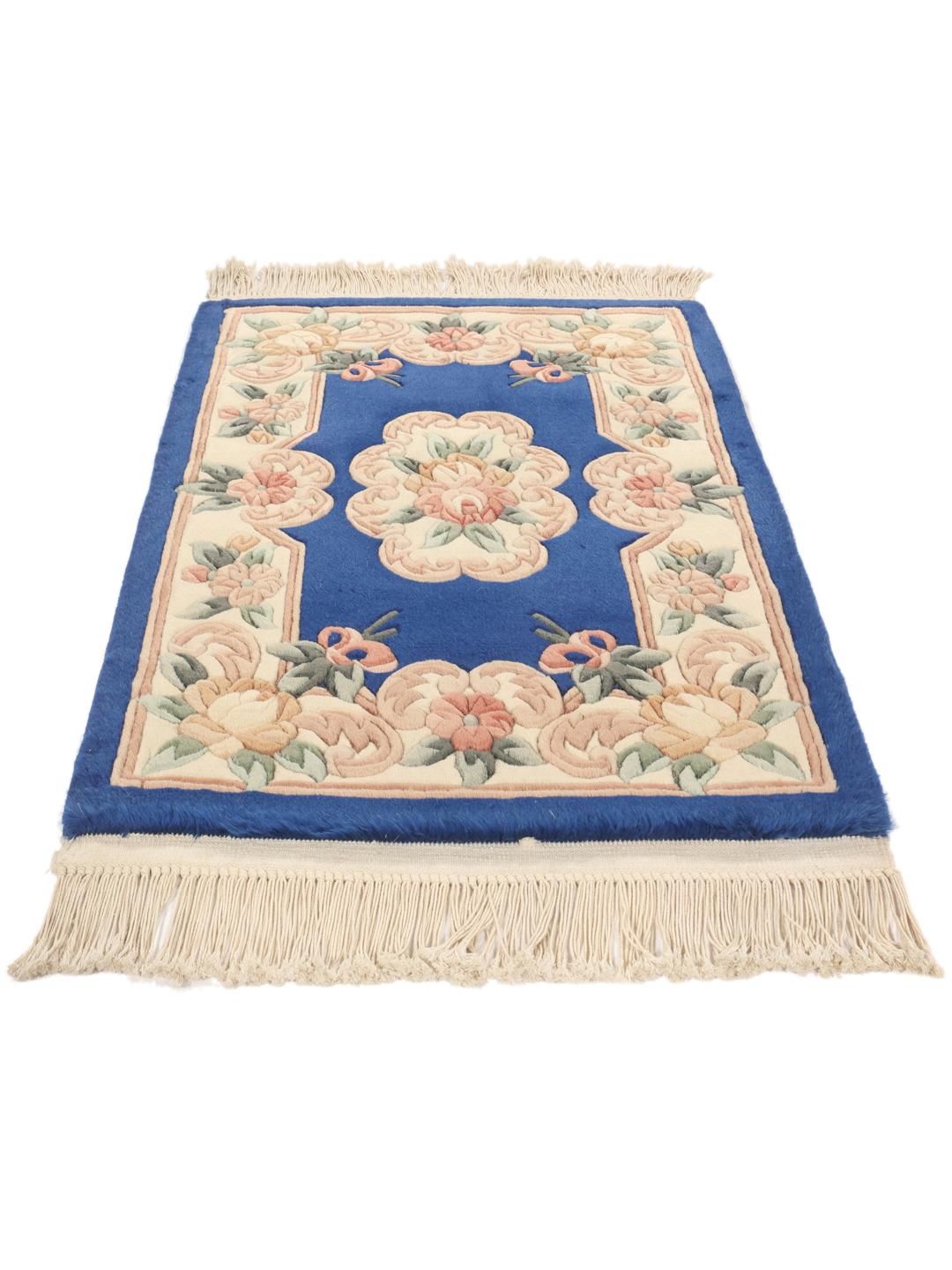 Et håndknyttet kinesisk tæppe med blå bund og blomstermotiver