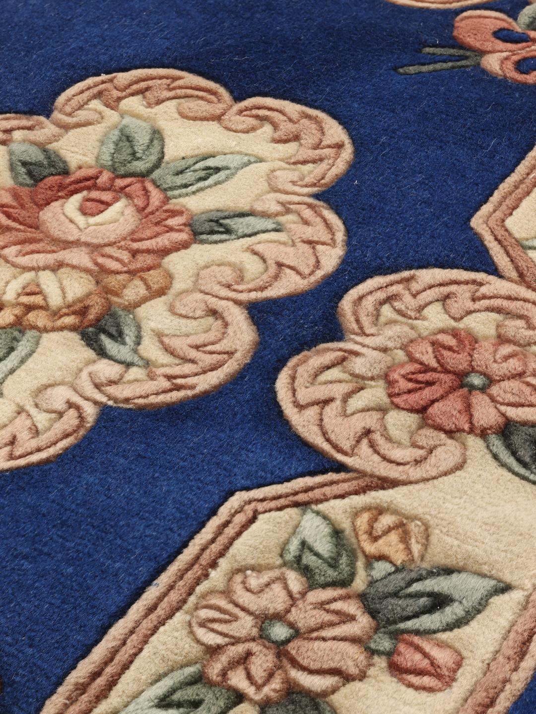 Et håndknyttet kinesisk tæppe med blå bund og blomstermotiver