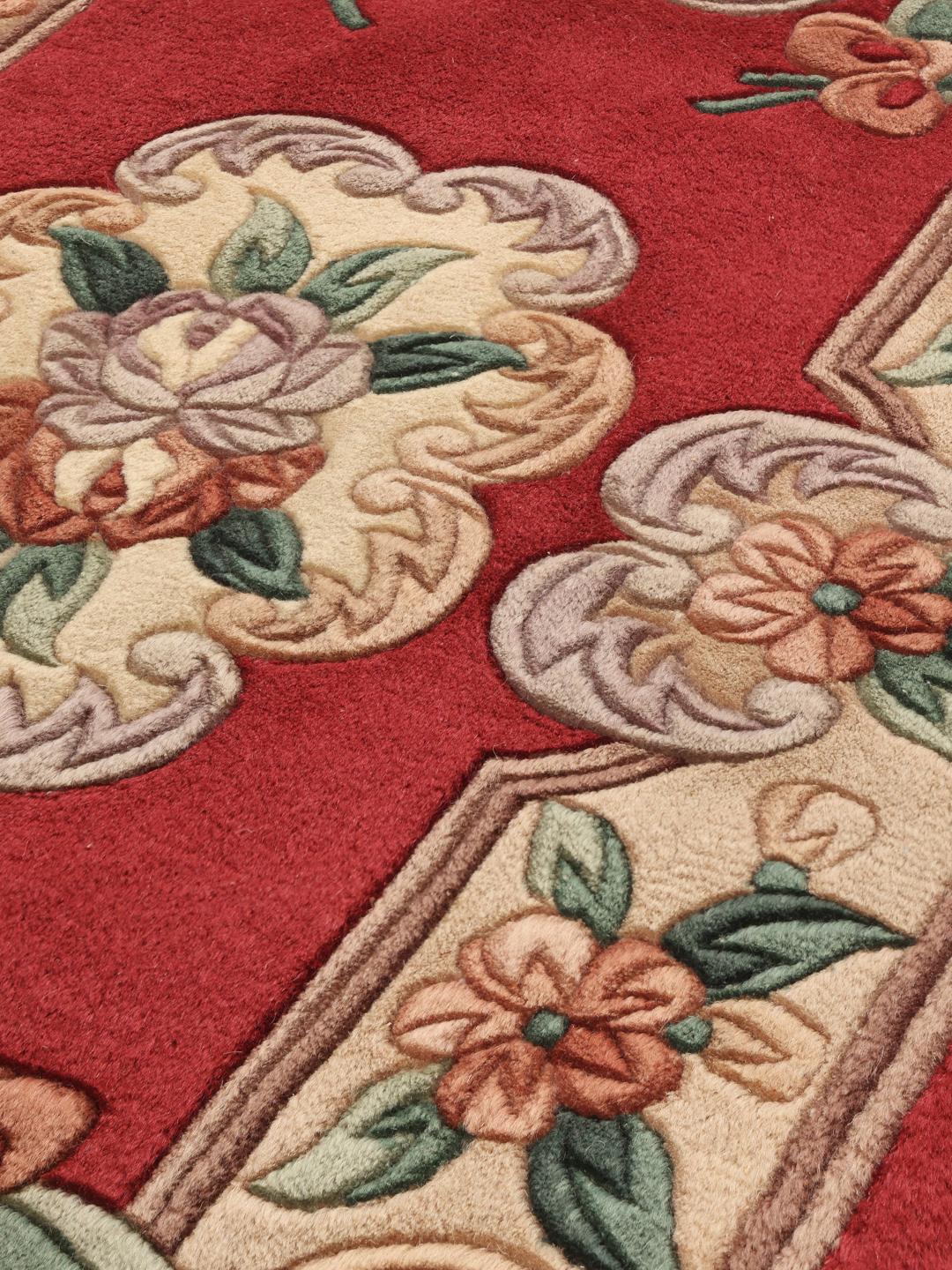 Håndknyttet kinesisk tæppe med blomstermotiver i røde, beige og grønne nuancer.