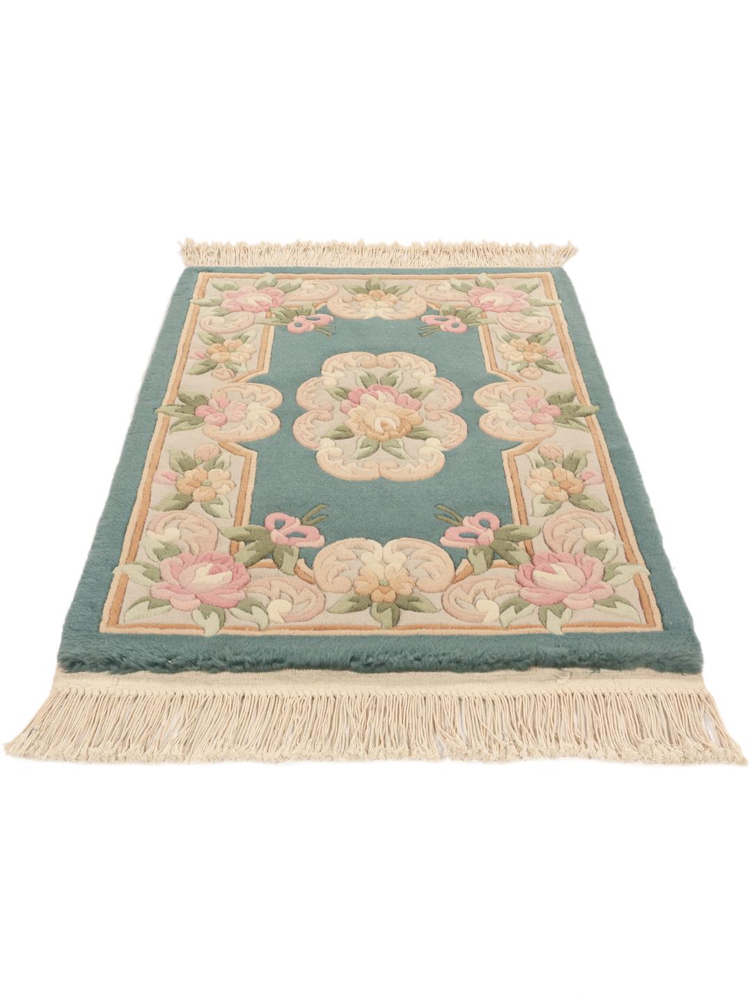 Et rektangulært kinesisk tæppe med blomstermønstre i nuancer af teal, lyserød og beige.